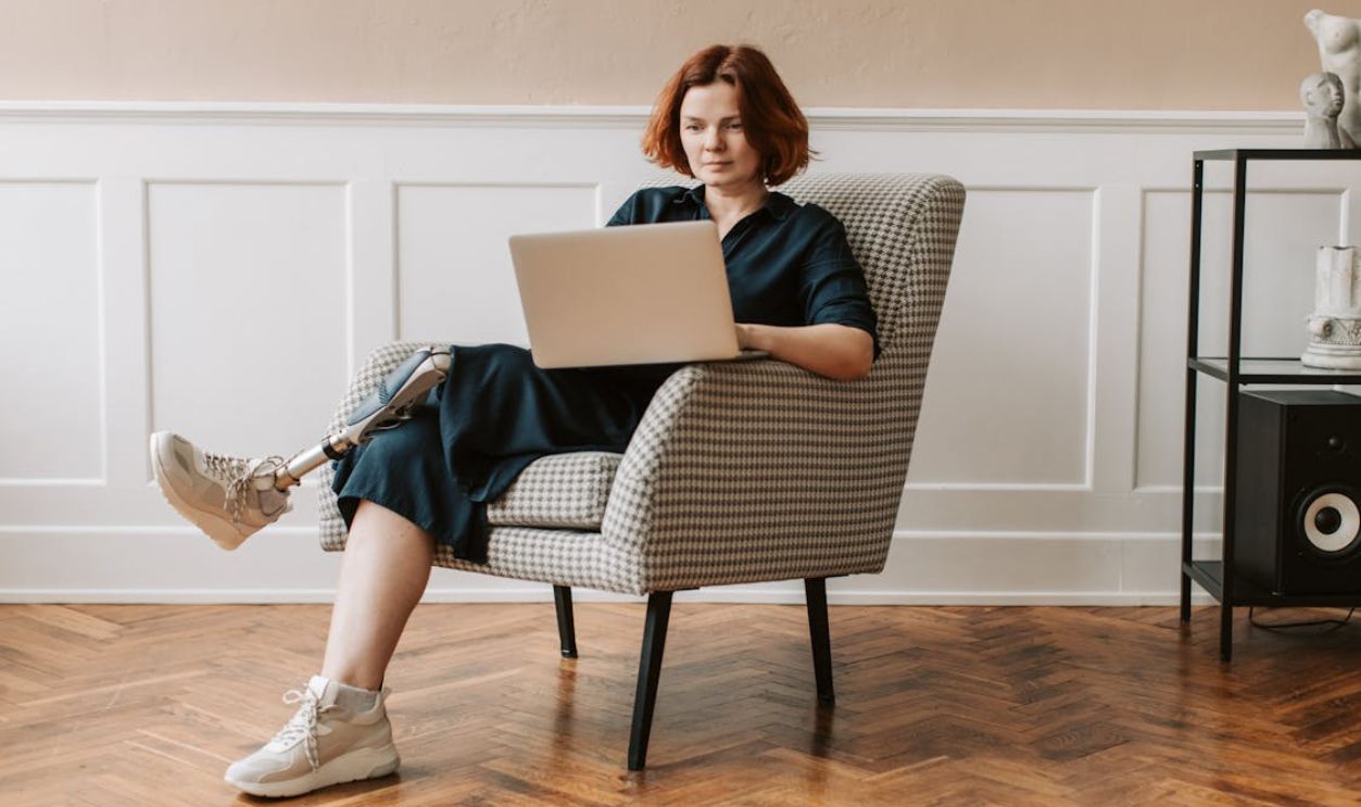Woman sitting on an Armchair using Laptop