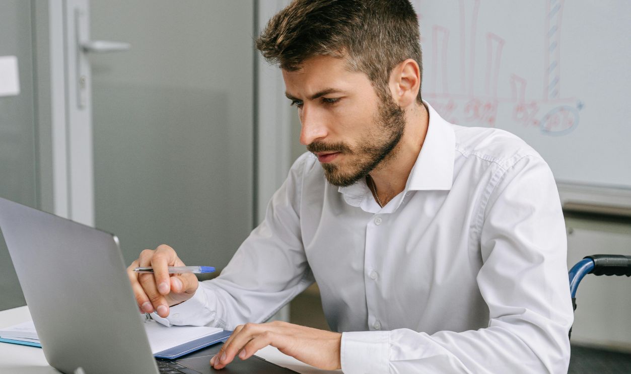 Man in White Dress Shirt Using a Laptop