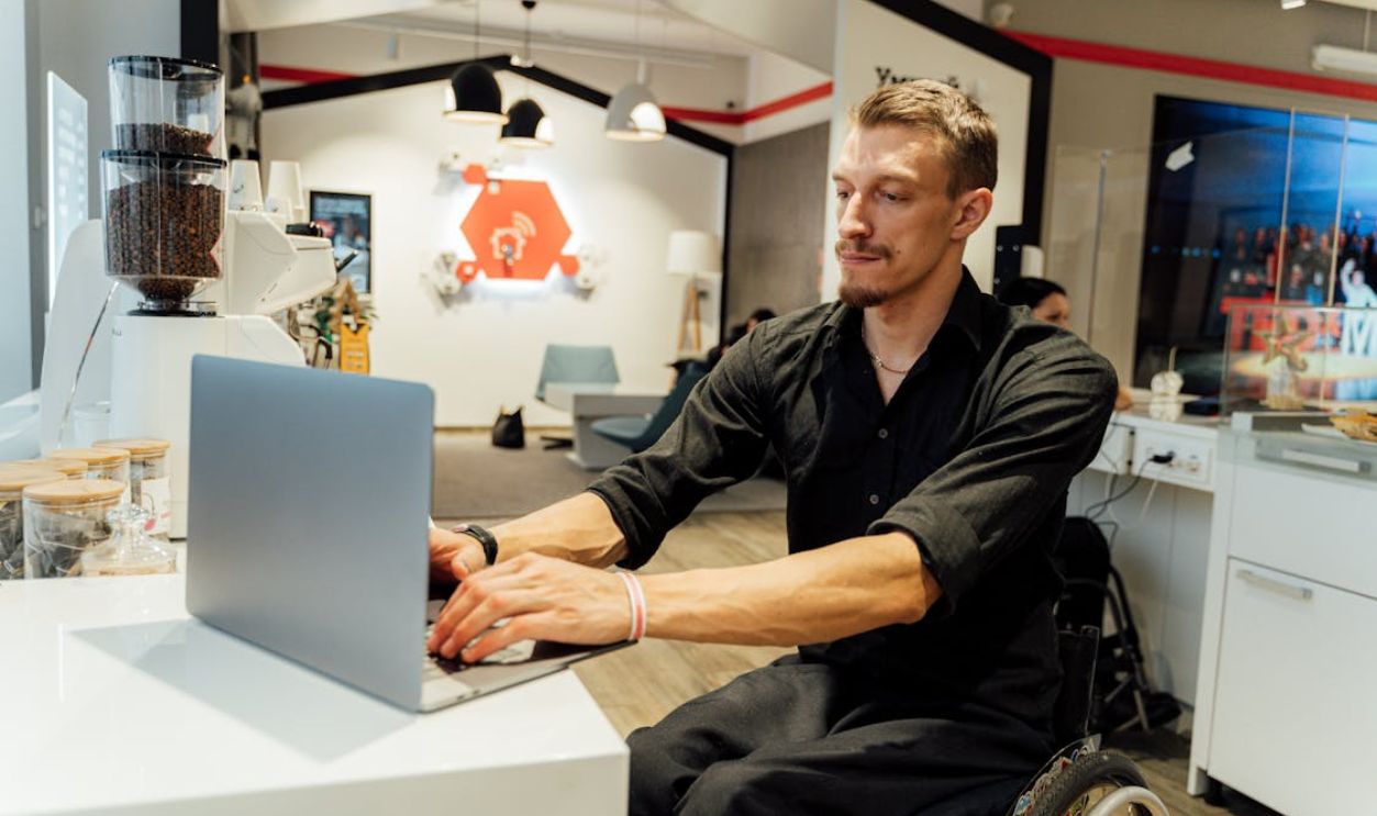 A Man in a Wheelchair Using a Laptop