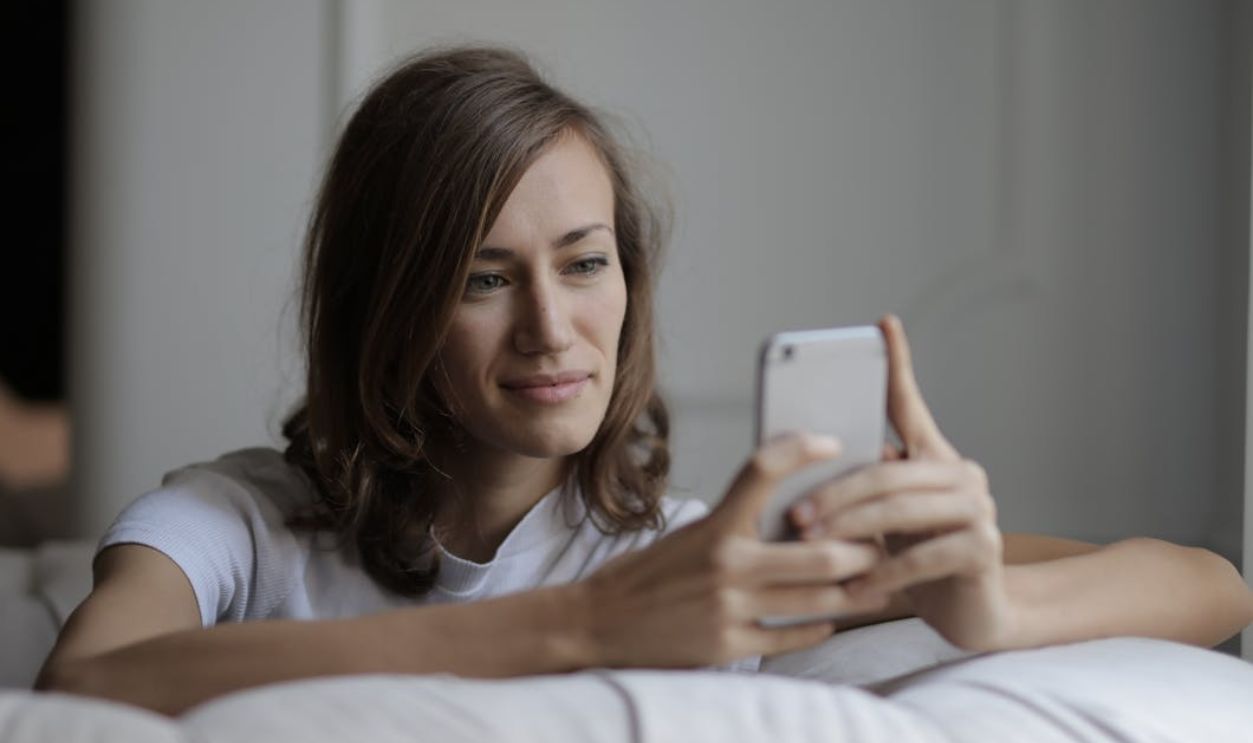 Woman in White Shirt Holding Silver Iphone 6