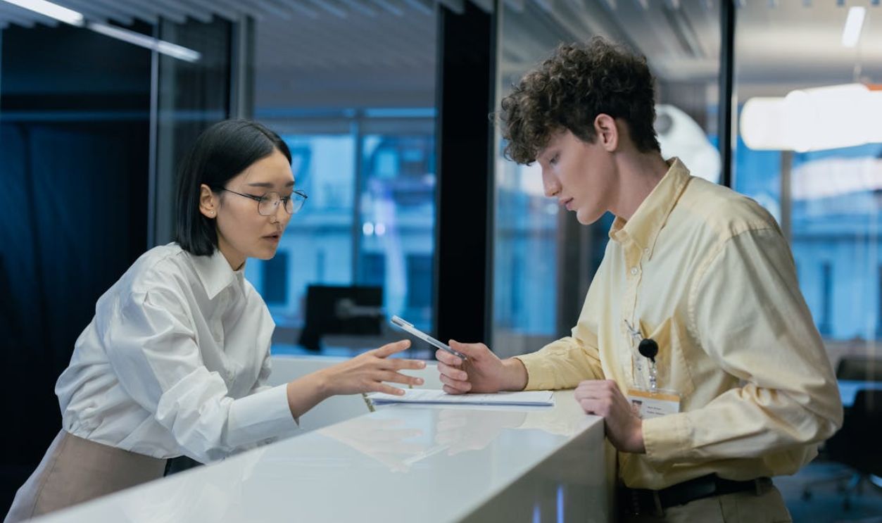 Recpetionist helping Man Fill Out Papers