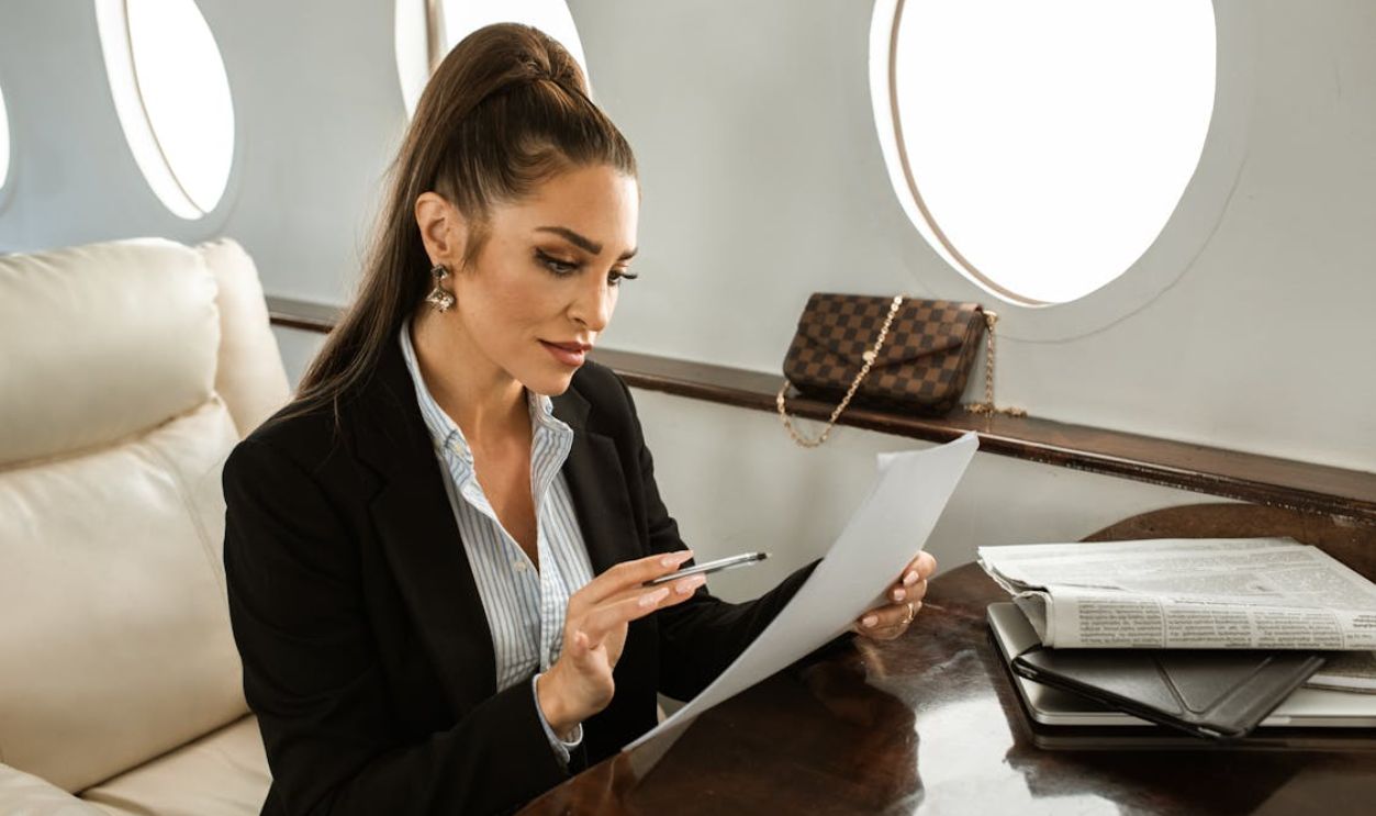 A Woman Reading a Document while in a Plane