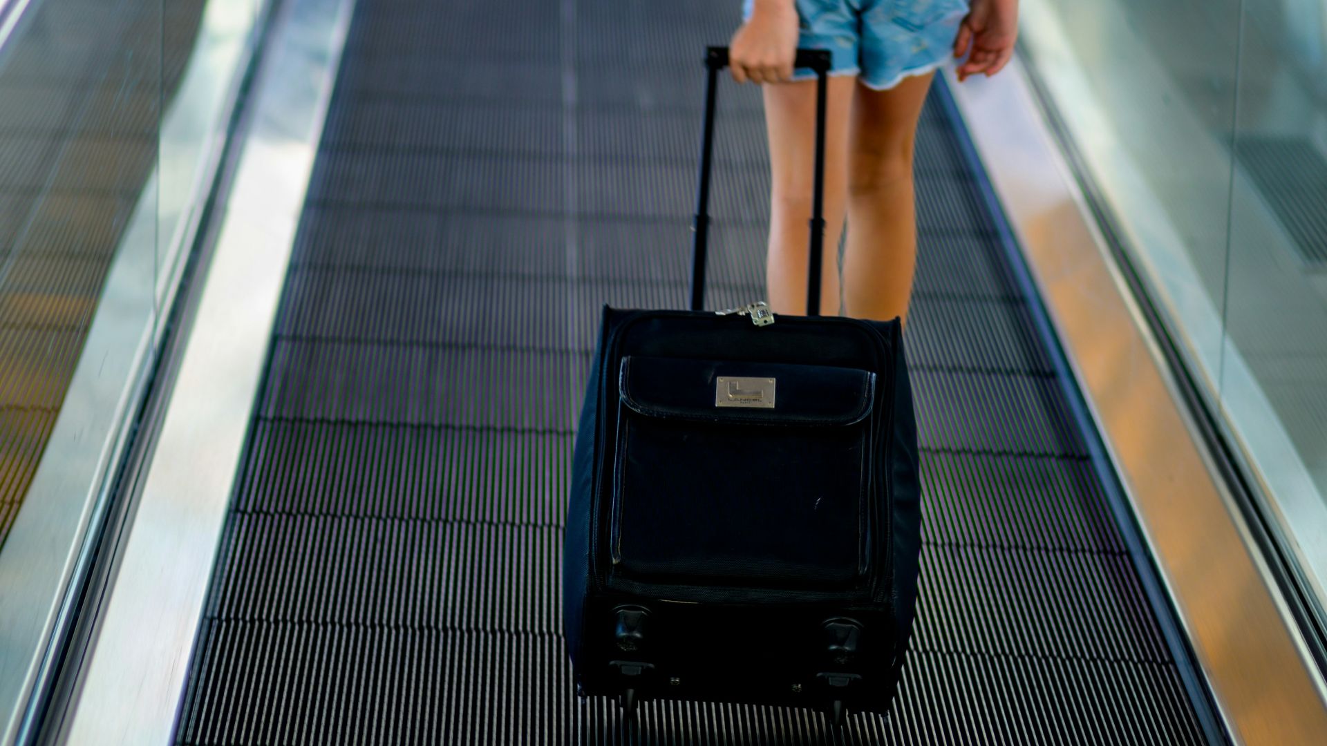 a person with a suitcase walking down a conveyor belt
