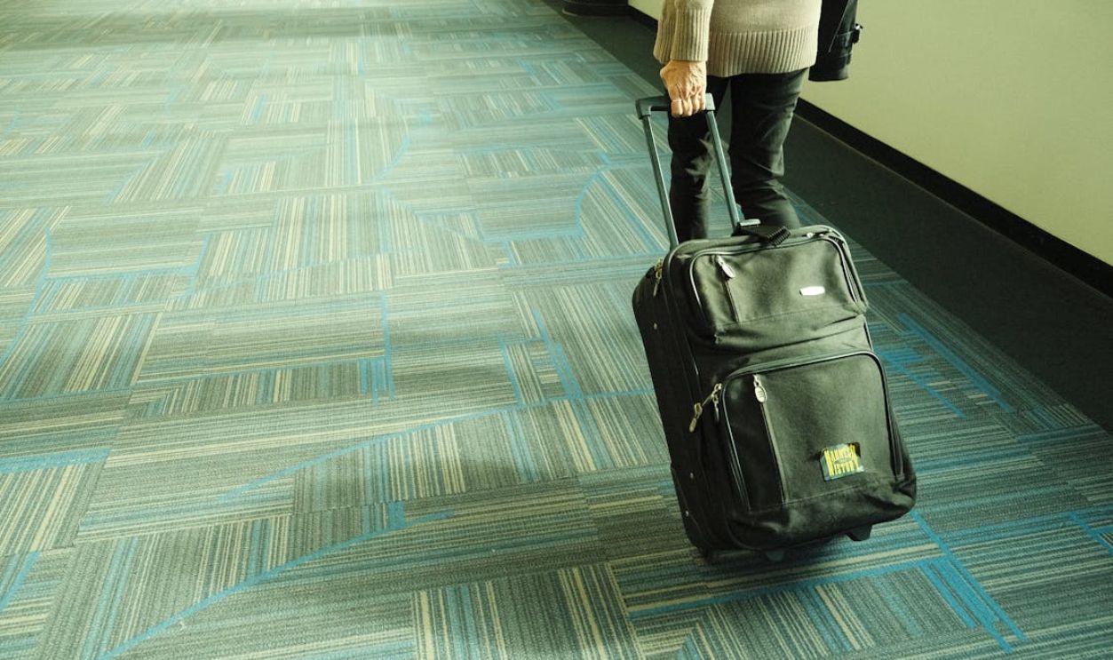 Traveler with luggage in airport corridor