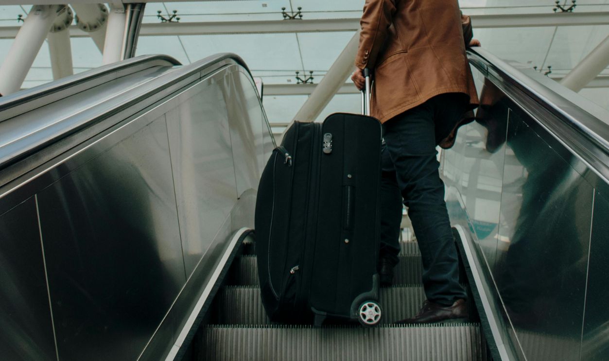 Man with Luggage on an Escalator