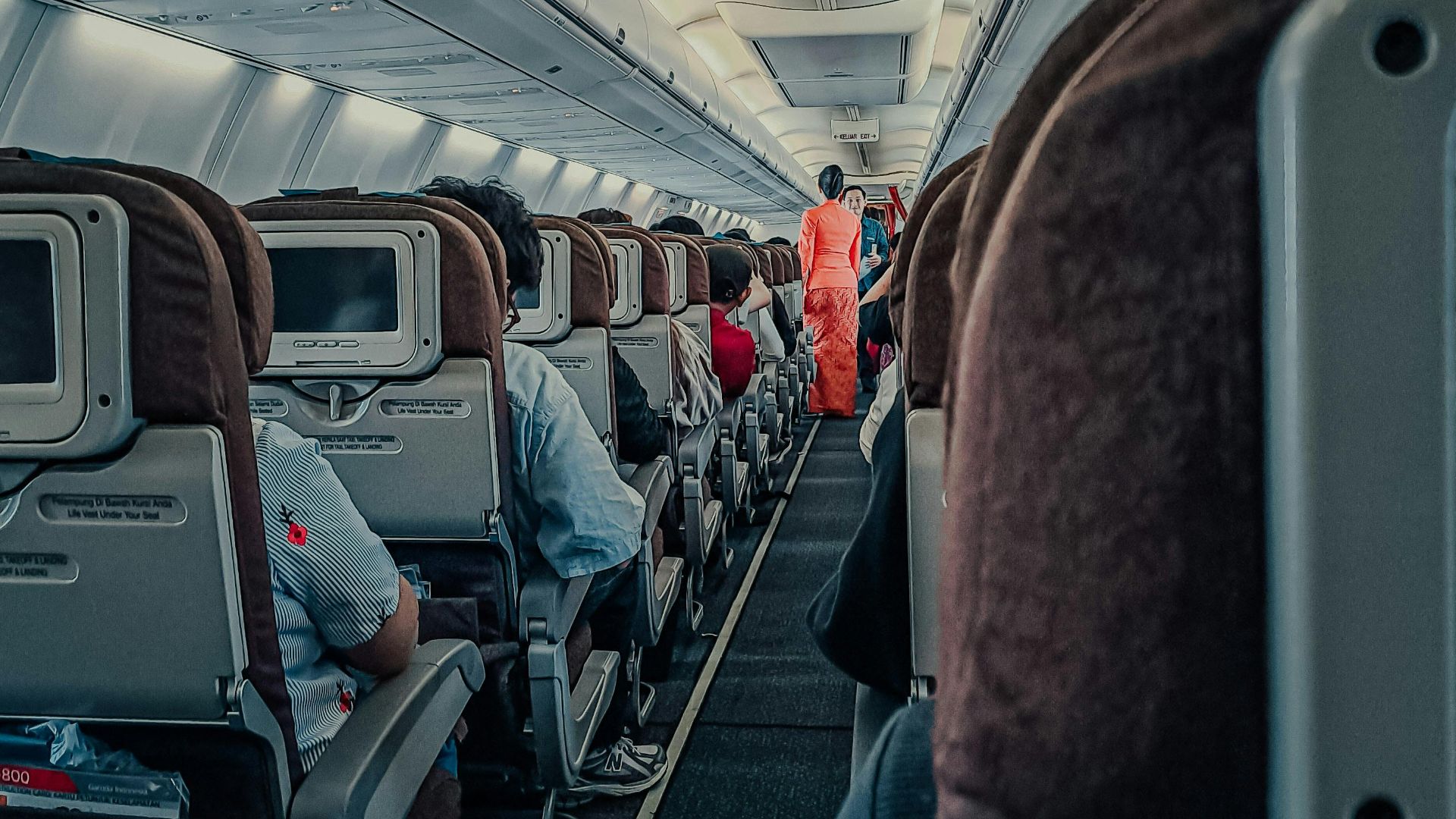 Interior of a commercial airplane with passengers seated, showcasing the cabin environment during flight.