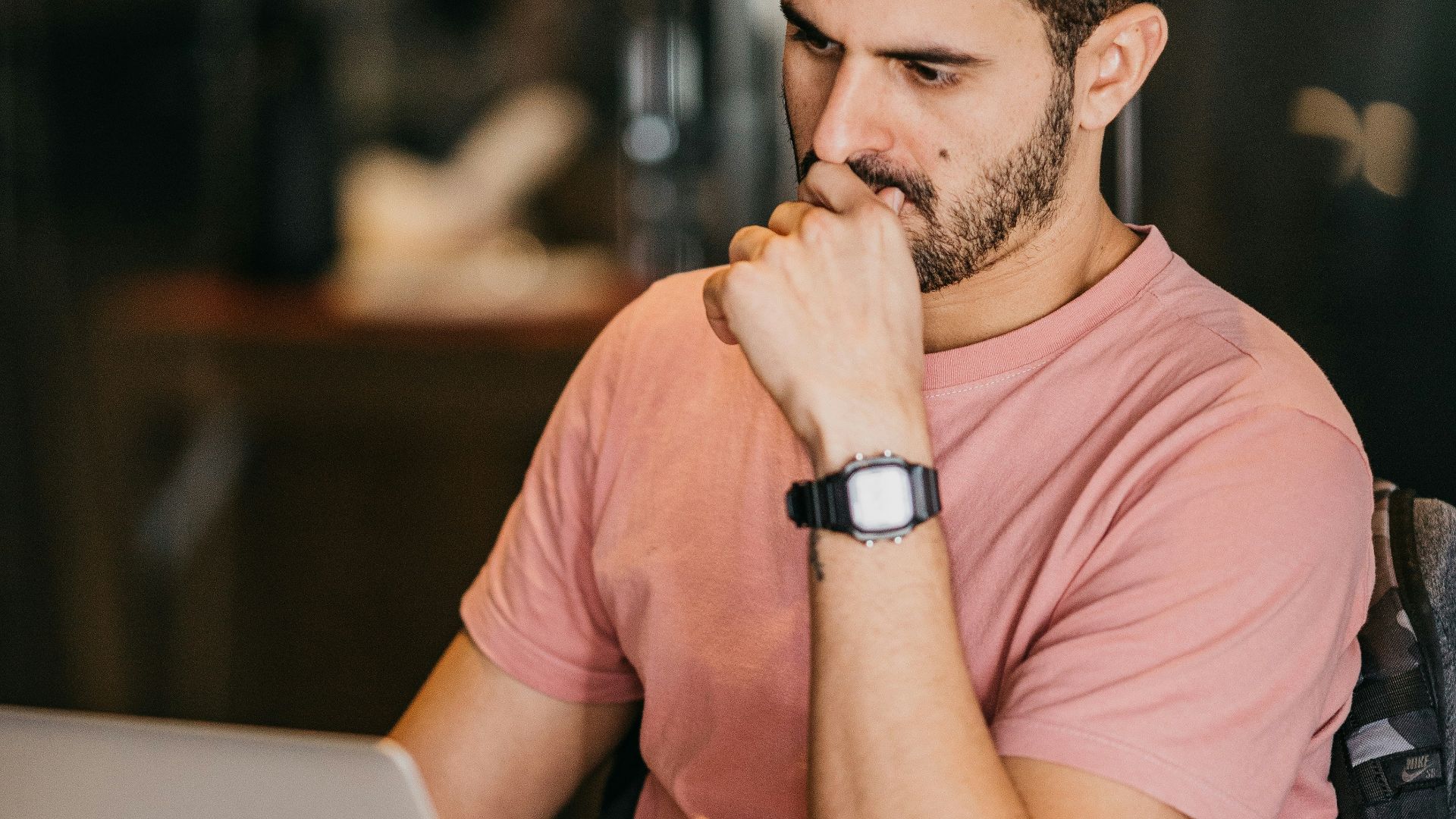 a man sitting at a table with a laptop and a cup