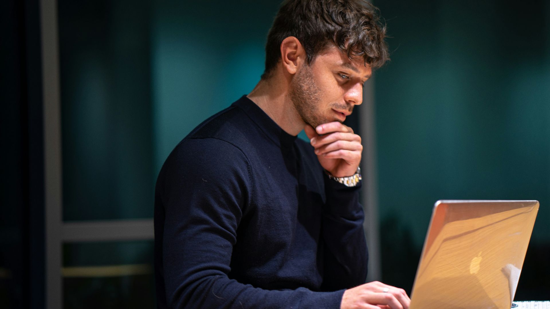 man in black long sleeve shirt sitting in front of macbook