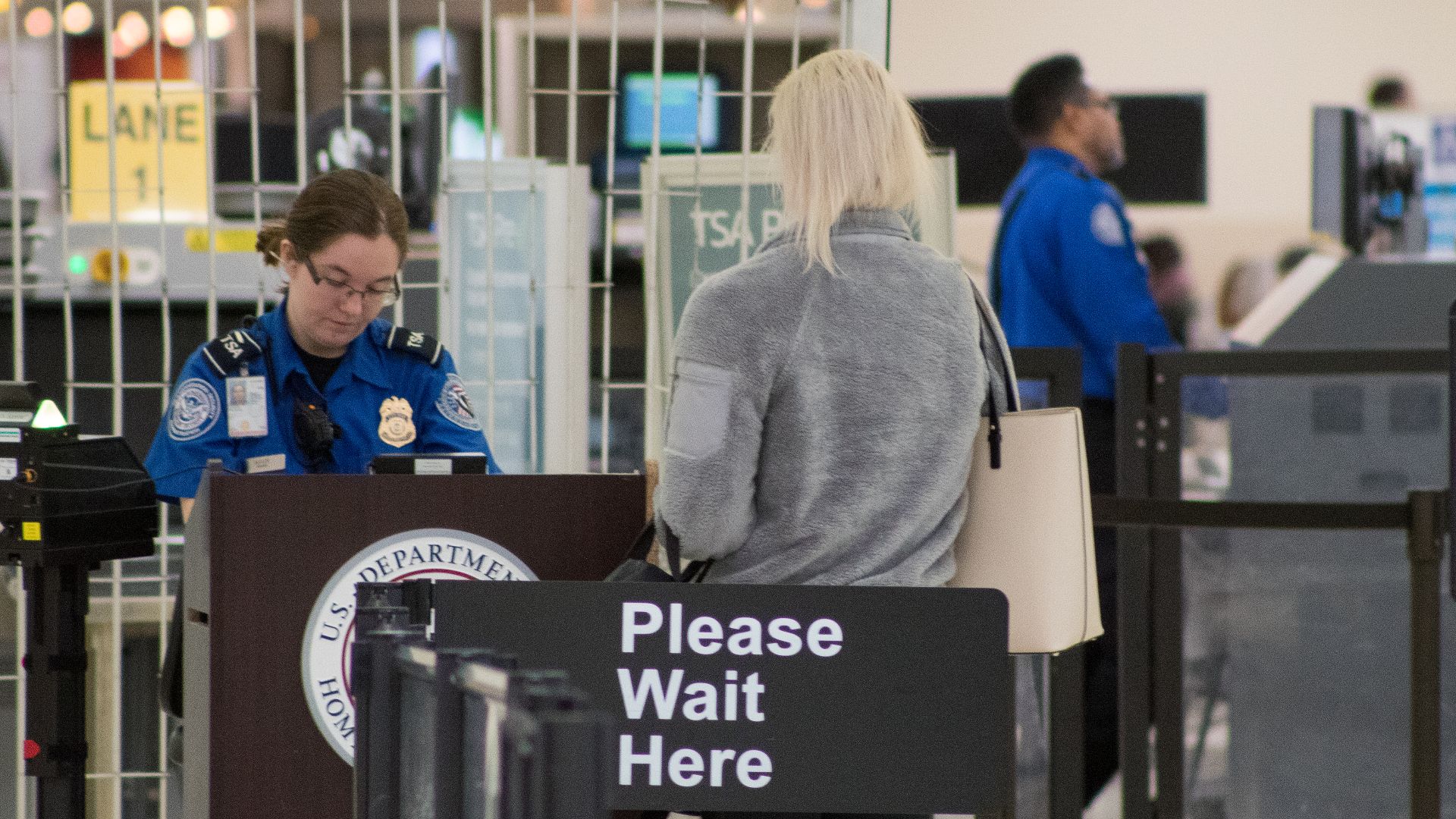 A Transportation Security Administration agent at a checkpoint verifying passenger identification, John Glenn Columbus International Airport