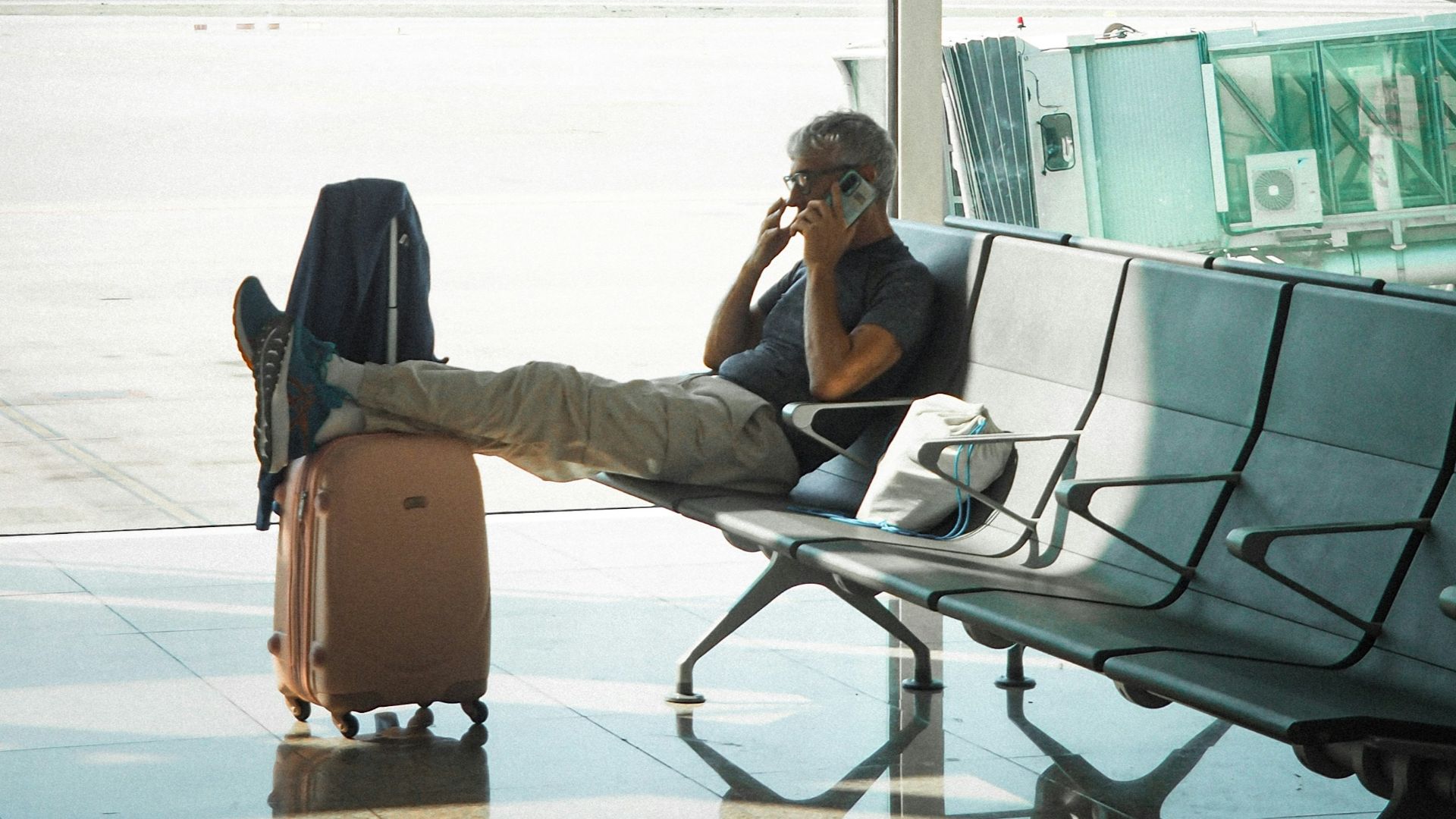 Man talking on phone in airport waiting area