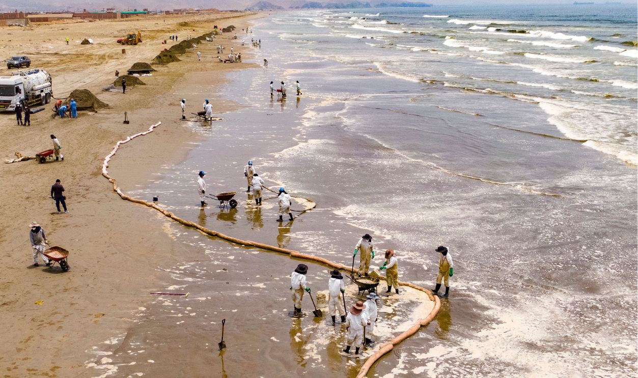 Aerial view as Repsol employees work on the clean-up of an oil spill on the shores of Cavero beach on January 20, 2022 in Ventanilla, Peru. Waves attributed to the eruption of underwater volcano Hunga-Tonga-Hunga-Ha'apai in Tonga produced an oil spill in the coast of Lima. According to information released by Peruvian Civil Defense Institute, a ship of Repsol was loading oil into La Pampilla refinery on January 16 when strong waves pushed the boat causing the spill, considered the worst ecological disaster in Peruvian recent history. 