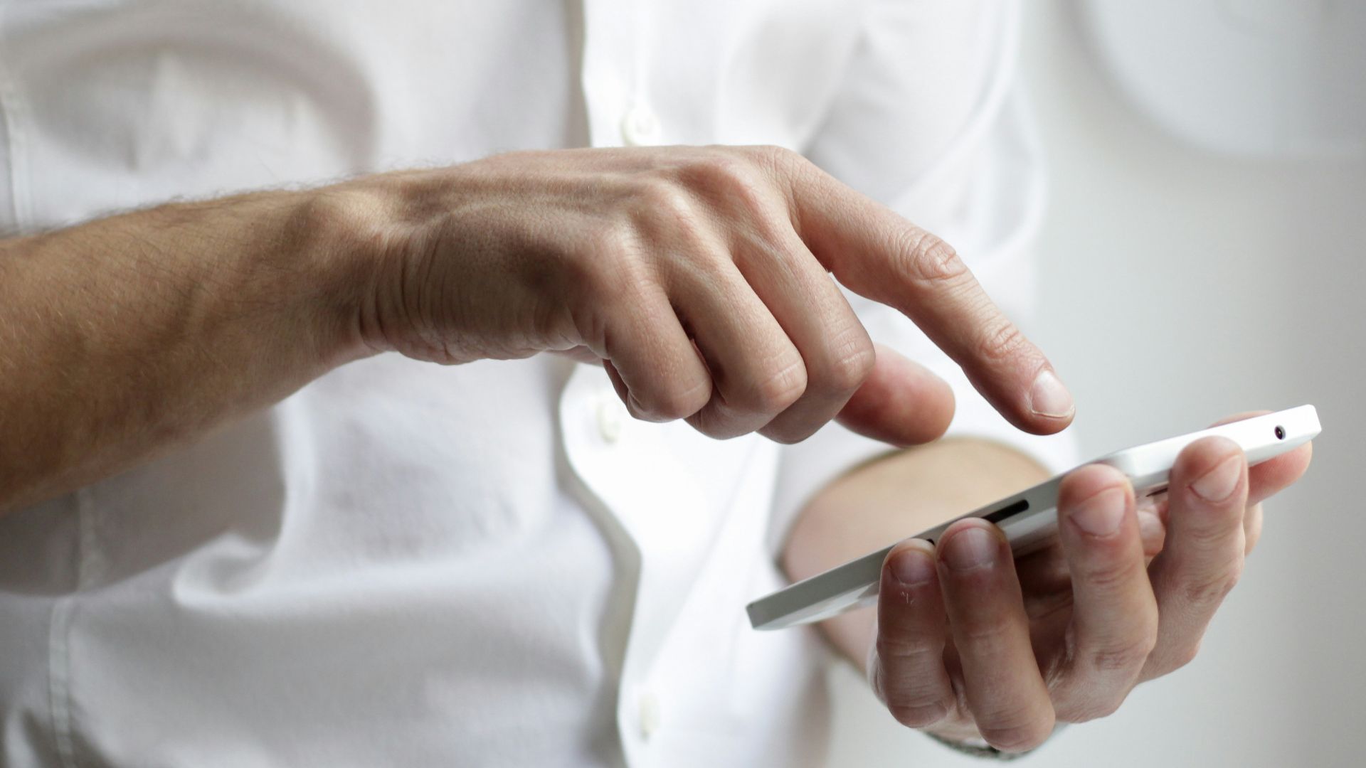 person holding white Android smartphone in white shirt