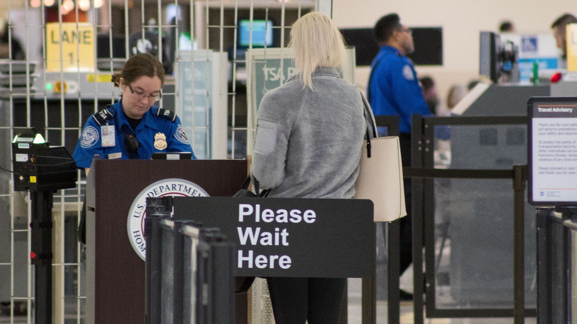 A Transportation Security Administration agent at a checkpoint verifying passenger identification, John Glenn Columbus International Airport