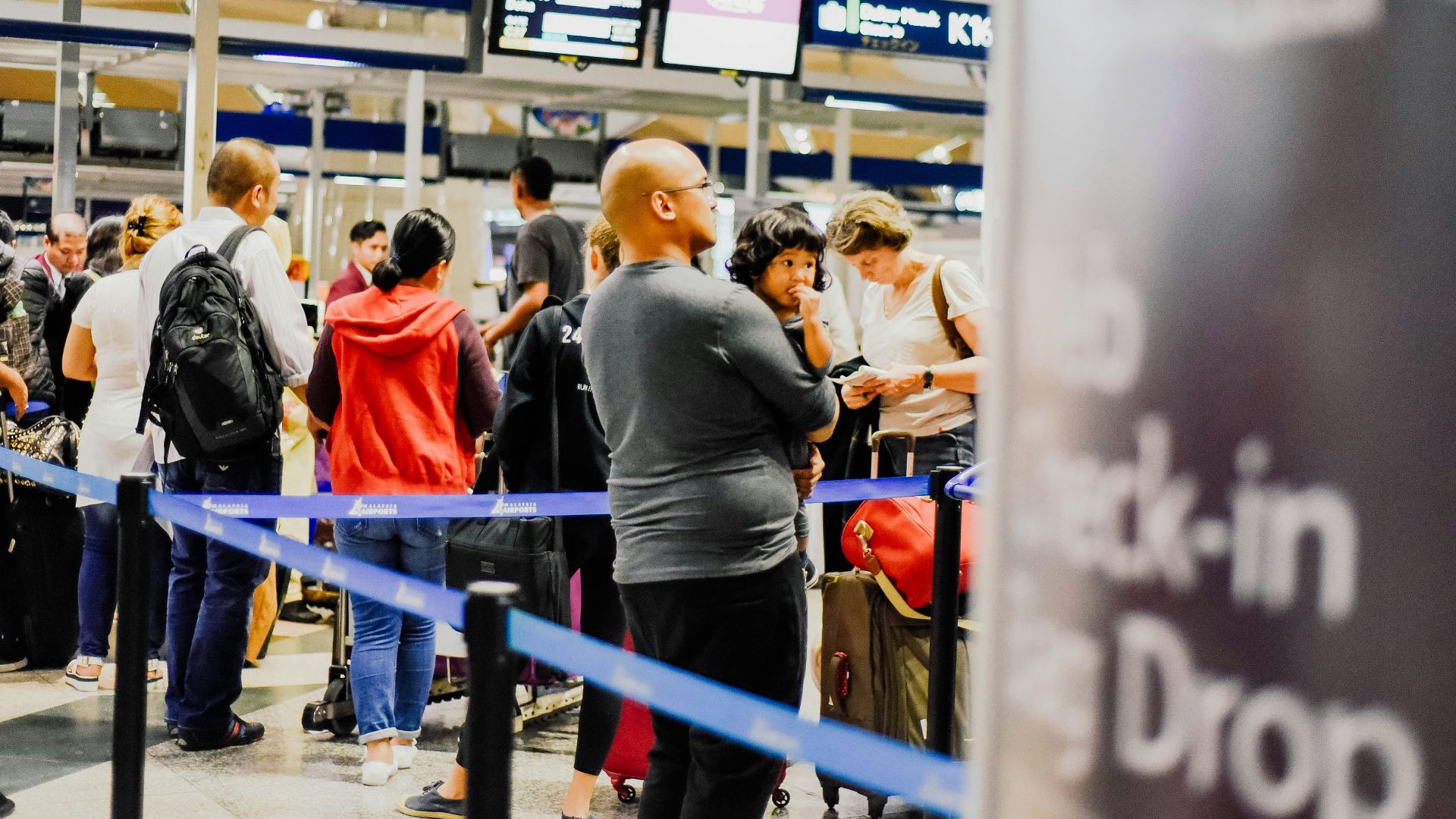 a group of people standing in a line at an airport
