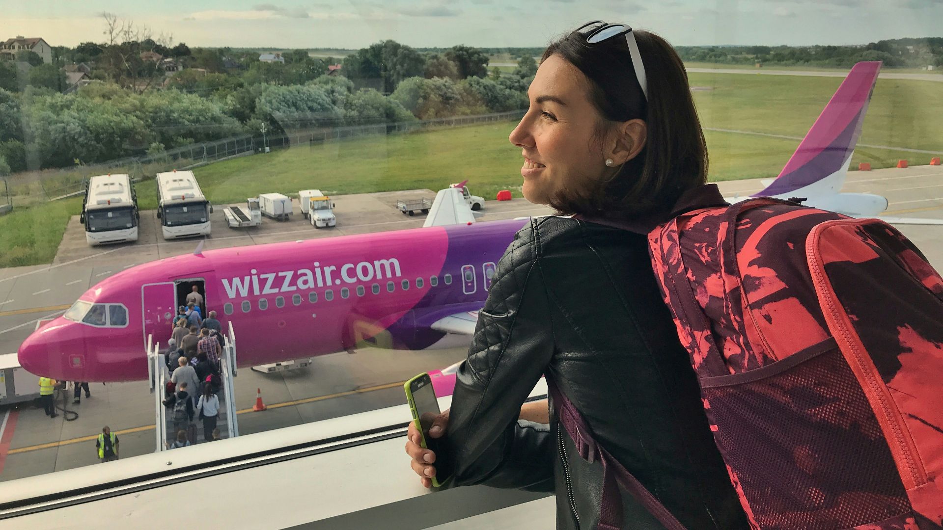 a woman looking out a window at an airplane