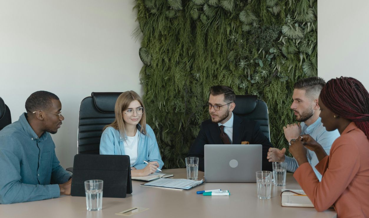 A group of diverse professionals discussing a project in a modern office setting.