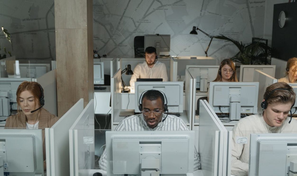 A diverse group of call center agents working in an organized office setting, focused on assisting customers
