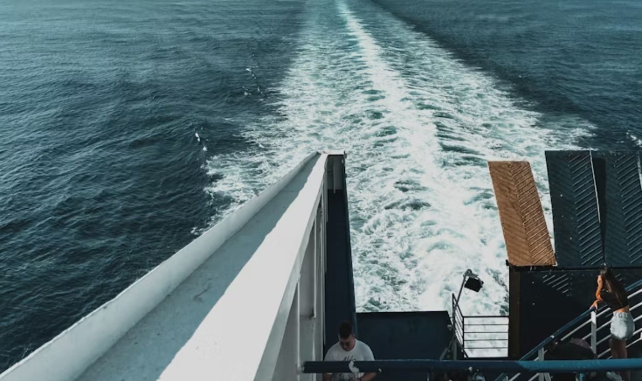 A ship sailing through large swells on deep ocean waters