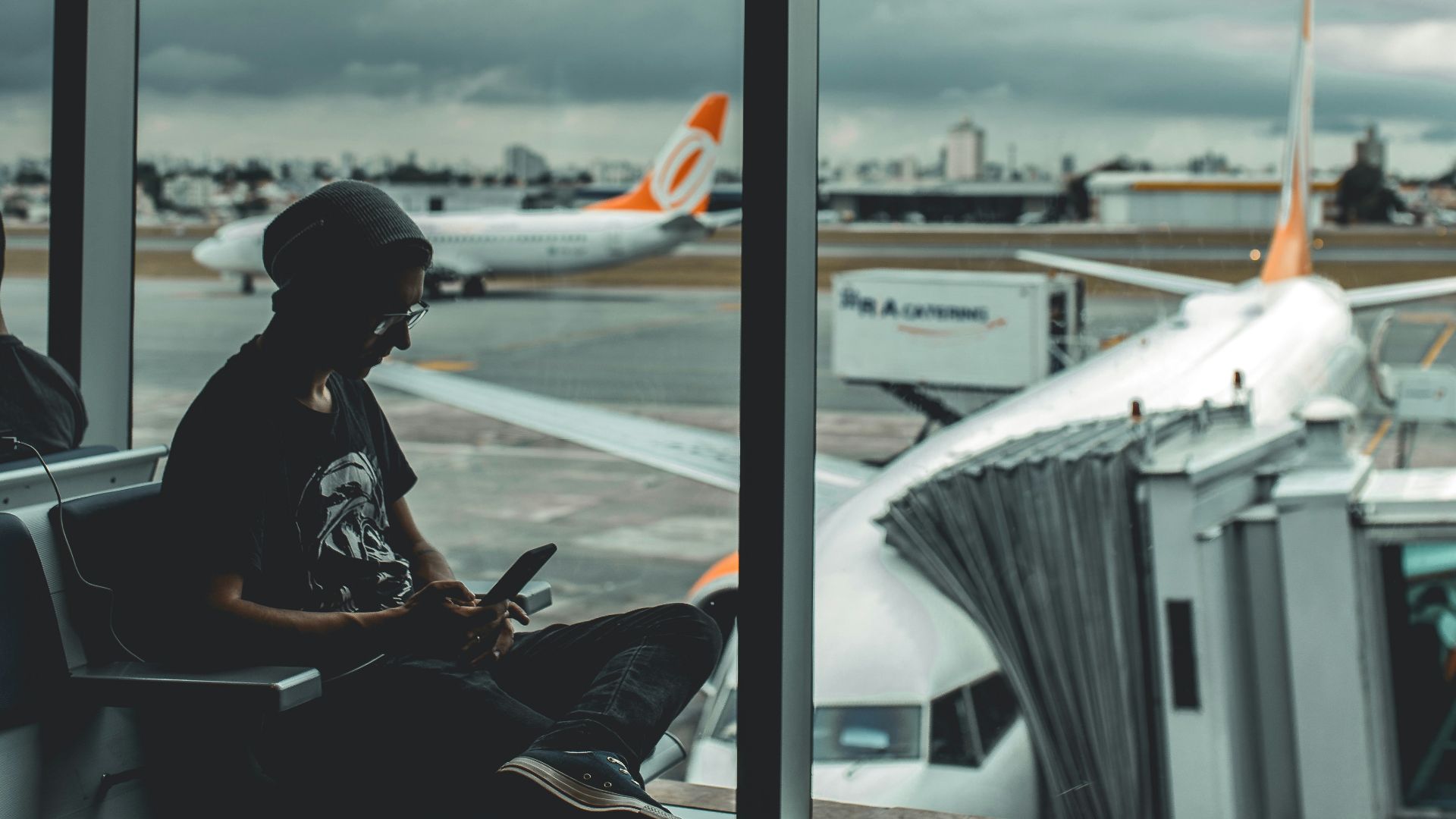 man browsing his phone in airport