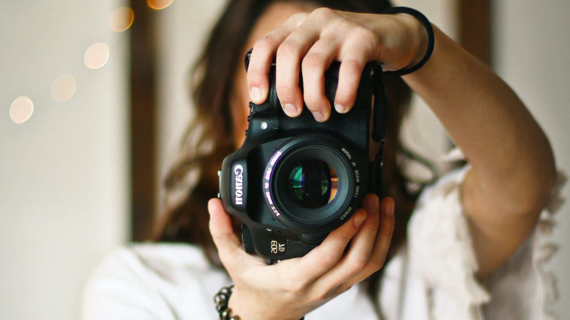 woman holding black DSLR camera