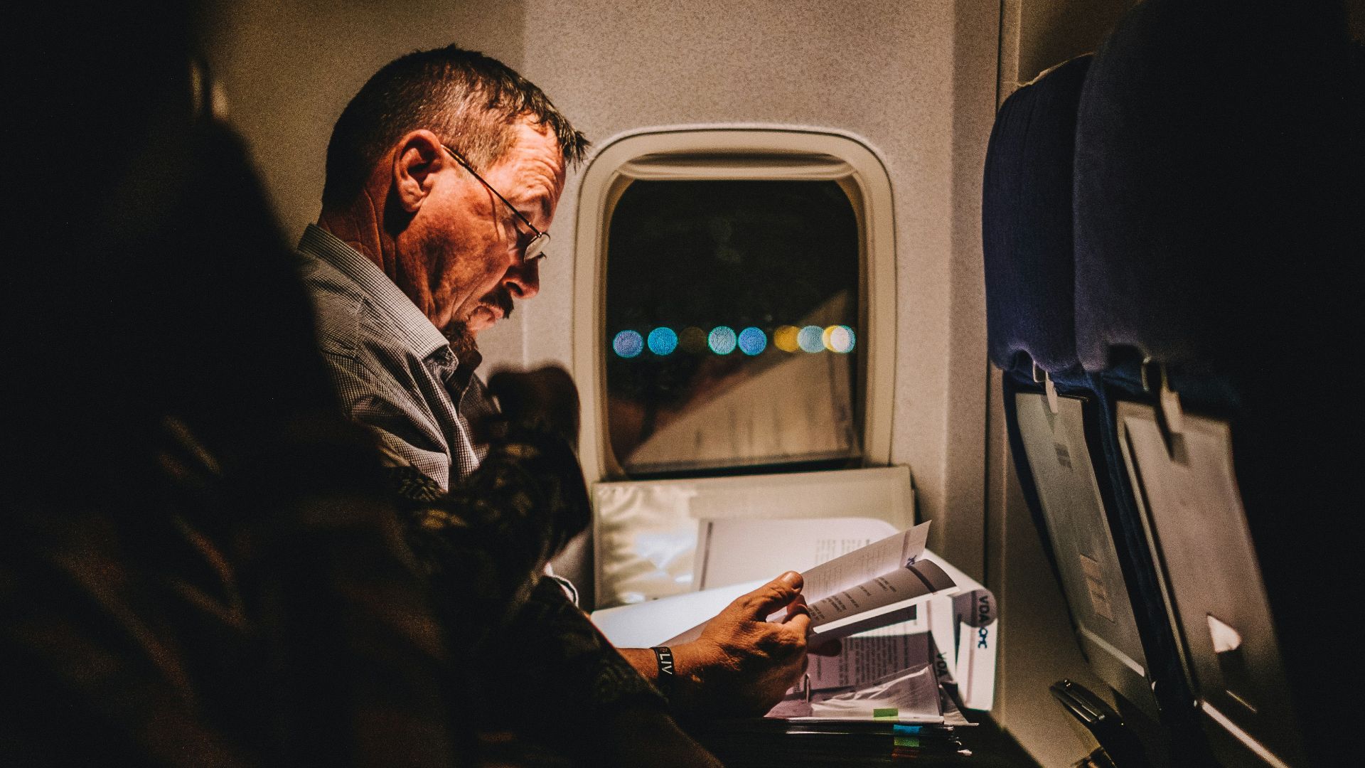 man reading book inside vehicle