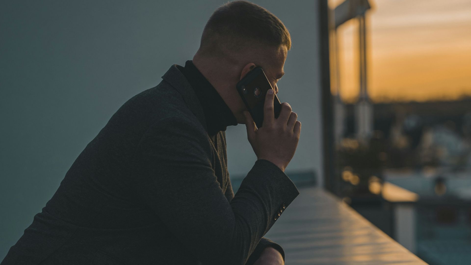 man in black long sleeve shirt sitting by the table