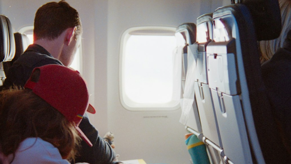 Passengers seated inside an airplane cabin during flight.