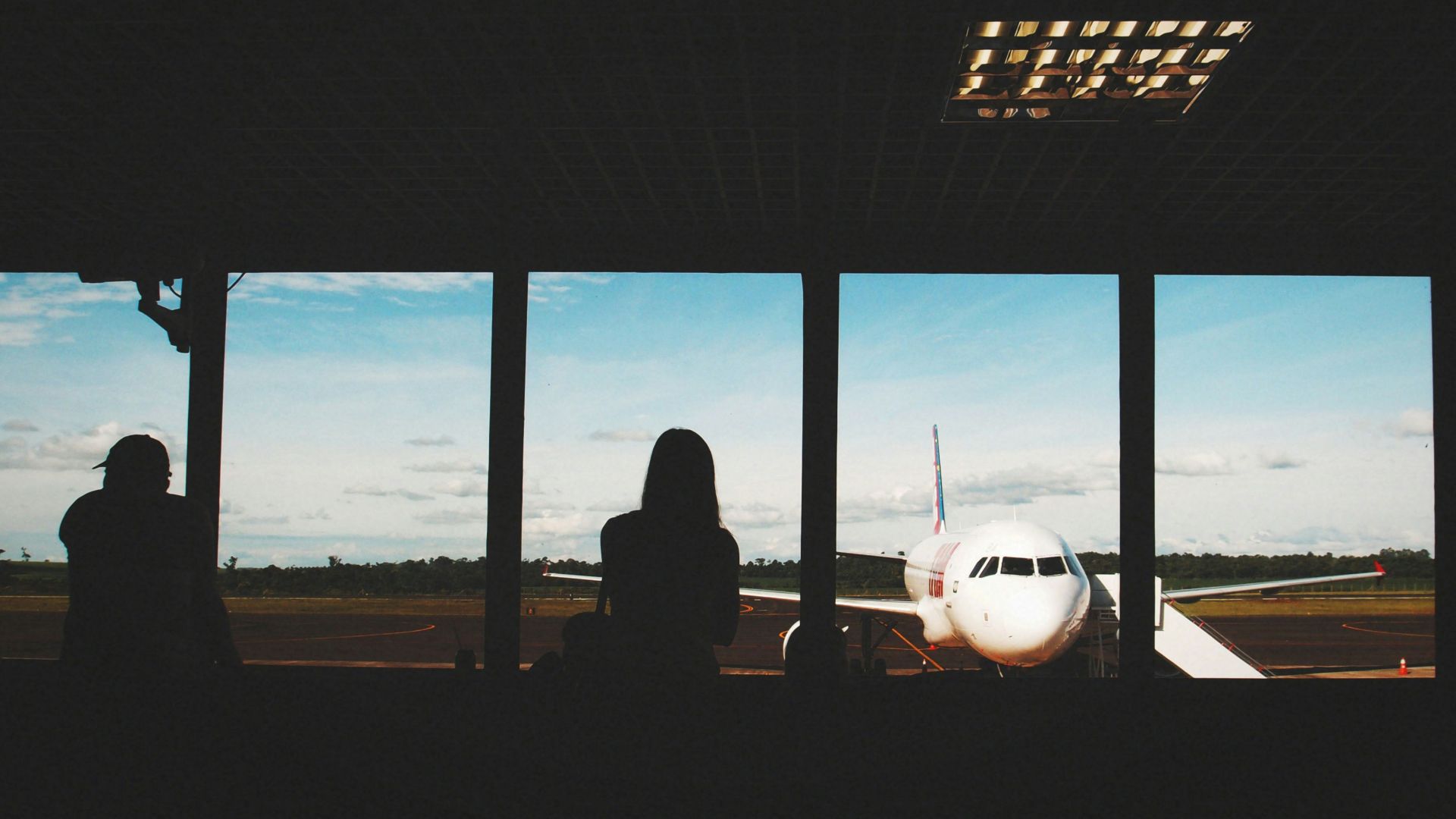 a group of people looking out a window at an airplane