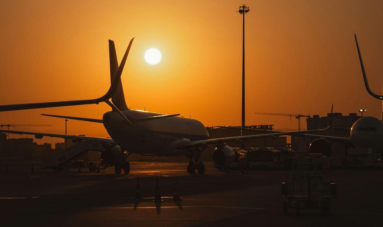 Silhouette of an airplane on the runway during a stunning sunset at Schwechat Airport, Austria