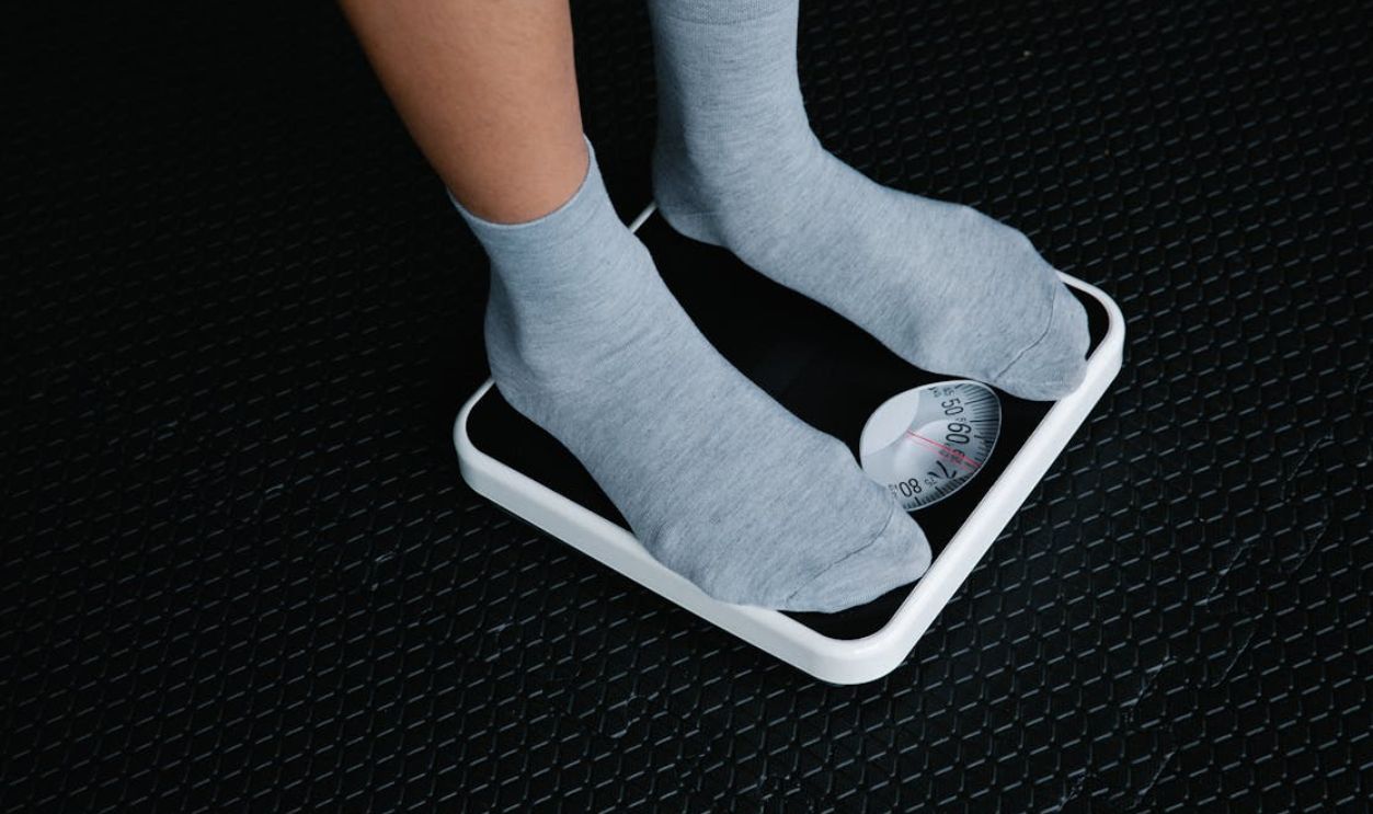 Close-up of feet in socks standing on a scale, focusing on weight measurement