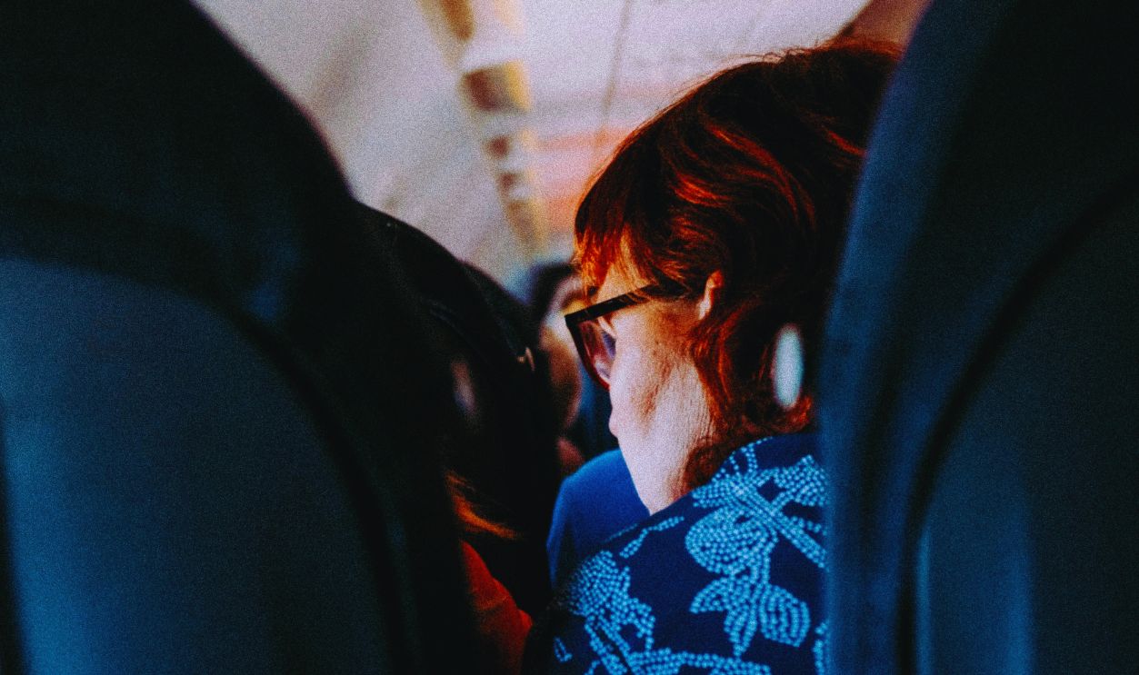 Woman sitting in an airplane cabin interior during daytime travel