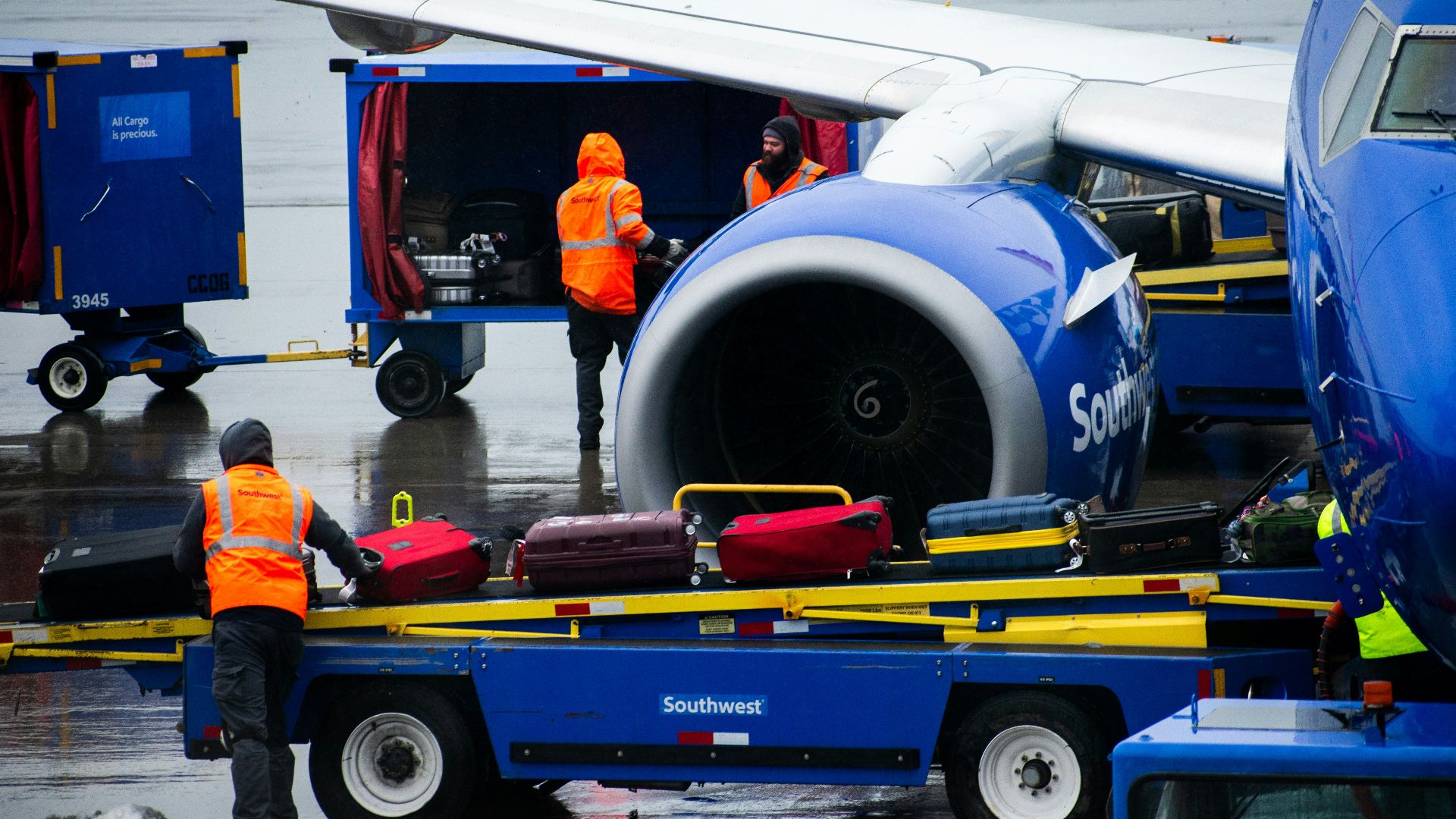An airplane being loaded with luggage on the tarmac