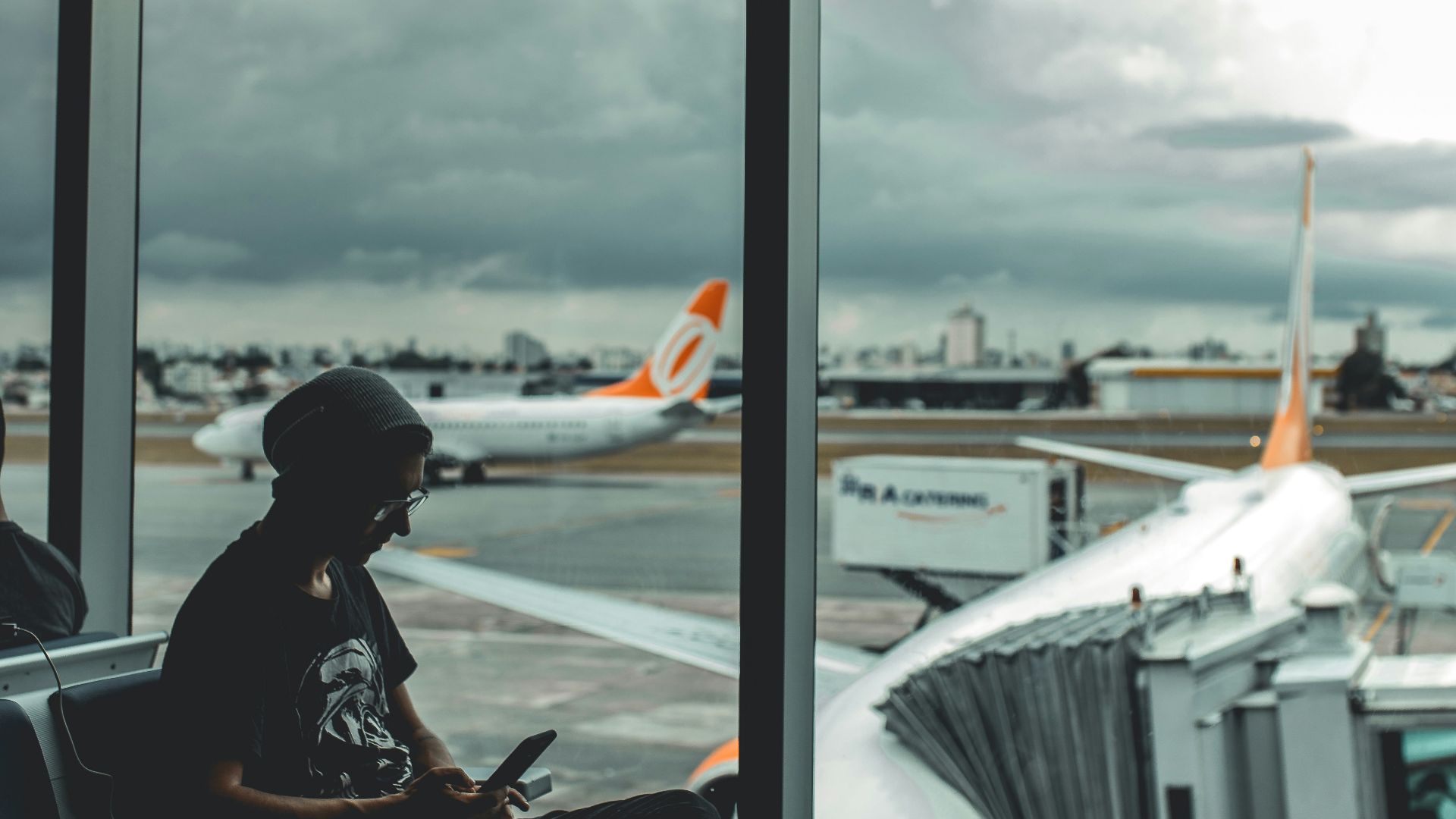 man browsing his phone in airport