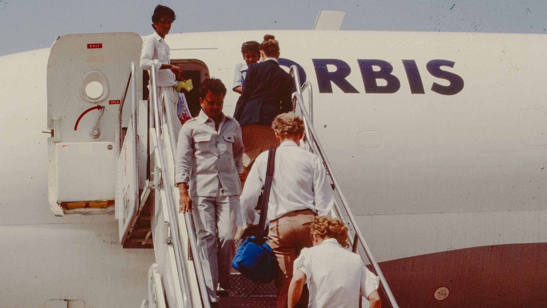 People boarding an airplane on stairs.