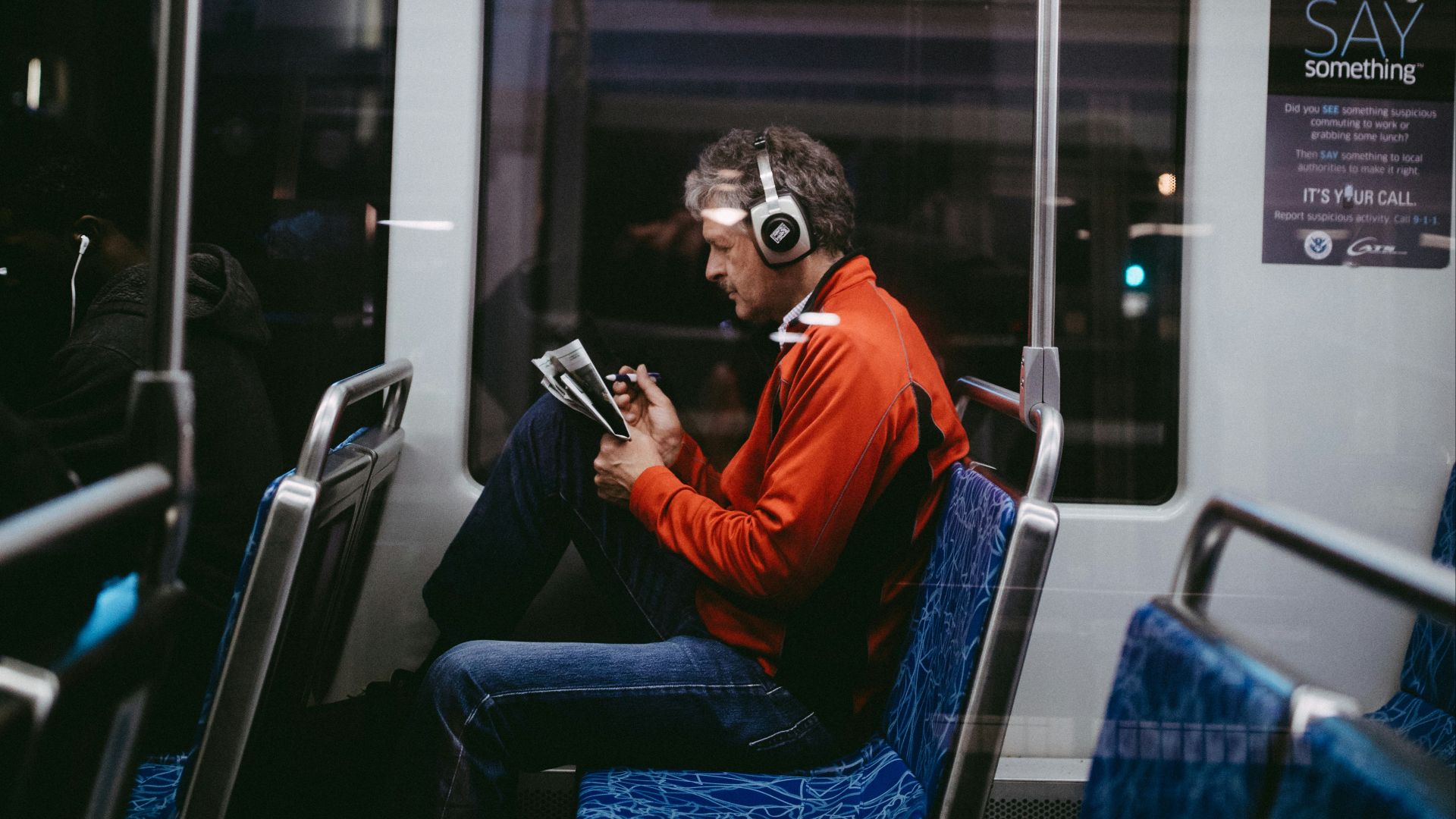 man sitting inside train while reading