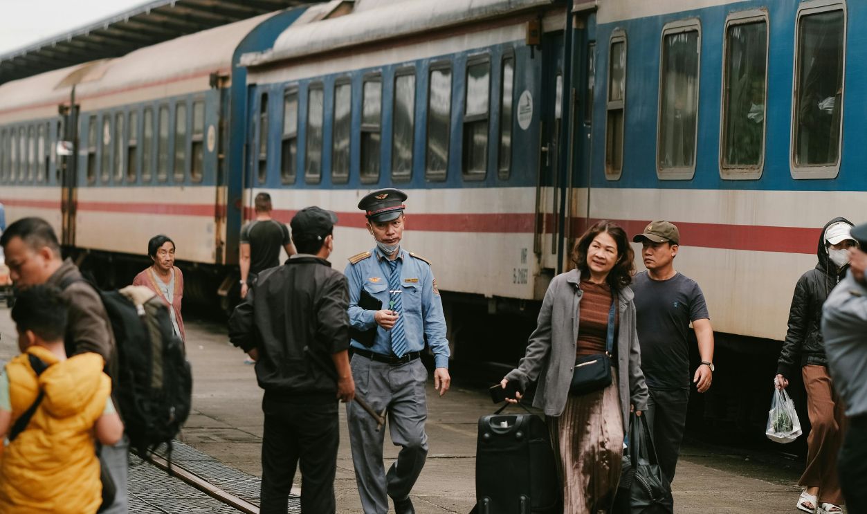 Passengers on a bustling railway platform with a train ready for departure, capturing travel moments