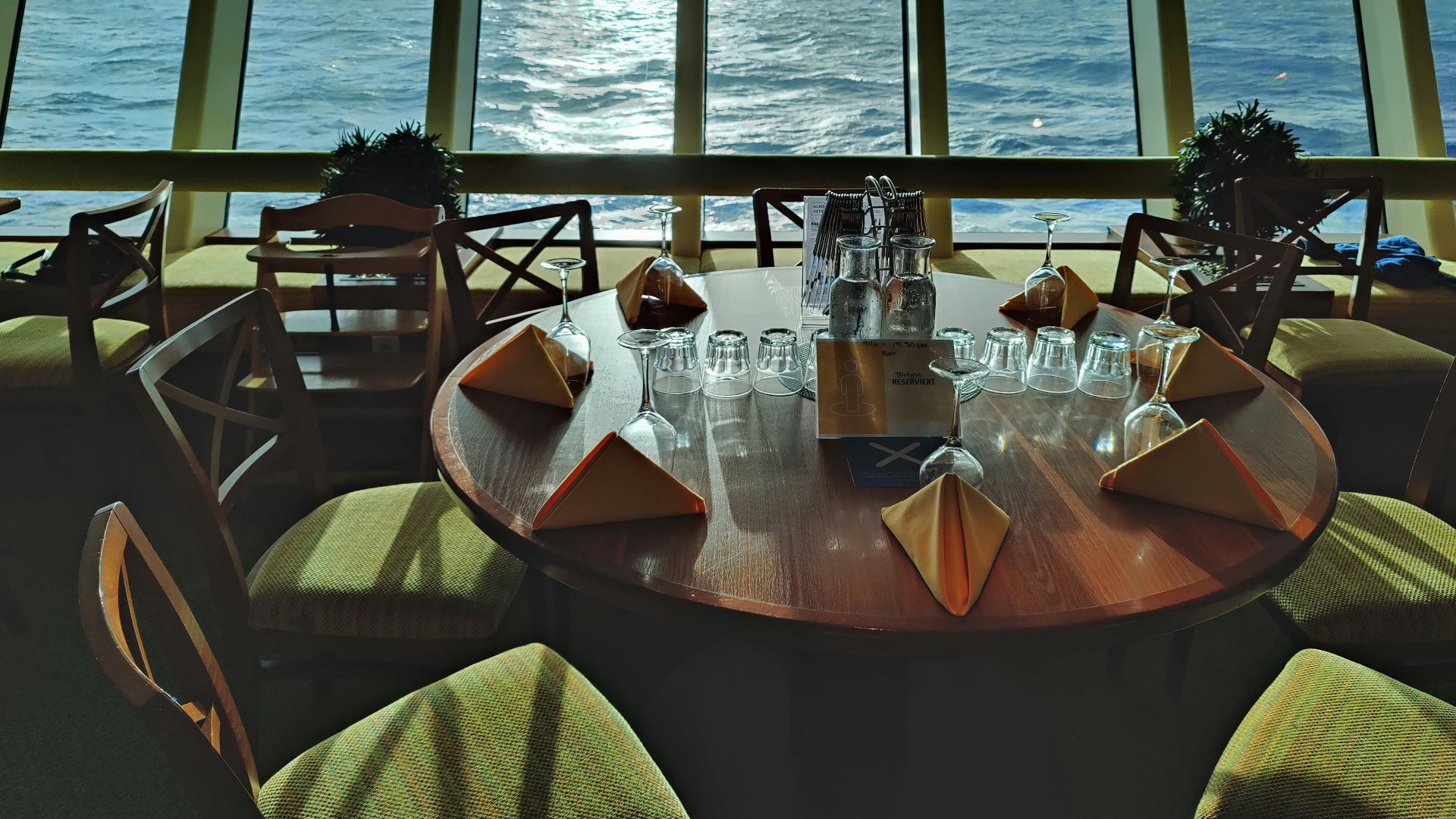 a table with glasses and bottles on it by a window with water