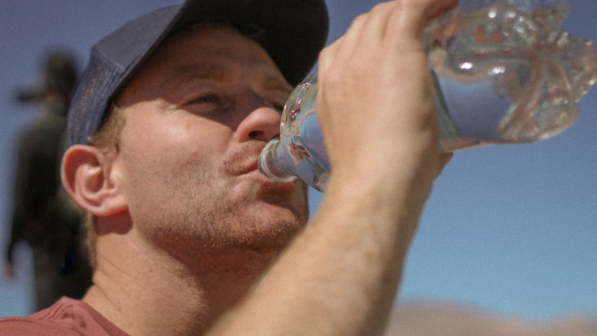 a man drinking water out of a bottle