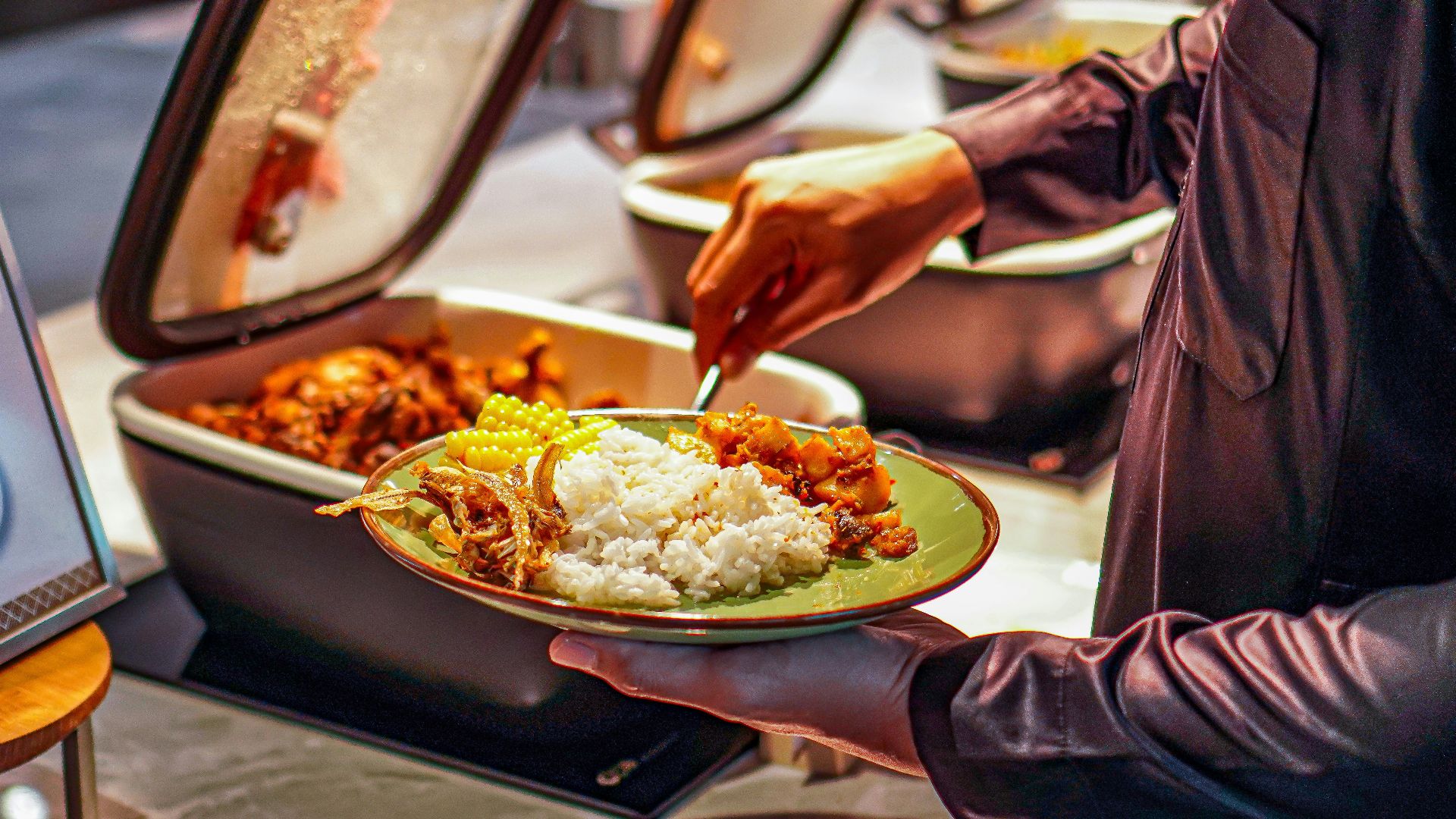 a person holding a plate of food in front of a sign