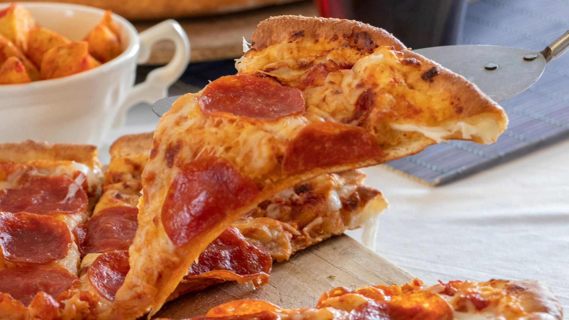 Close-up of mouth-watering pepperoni pizza served with a drink.