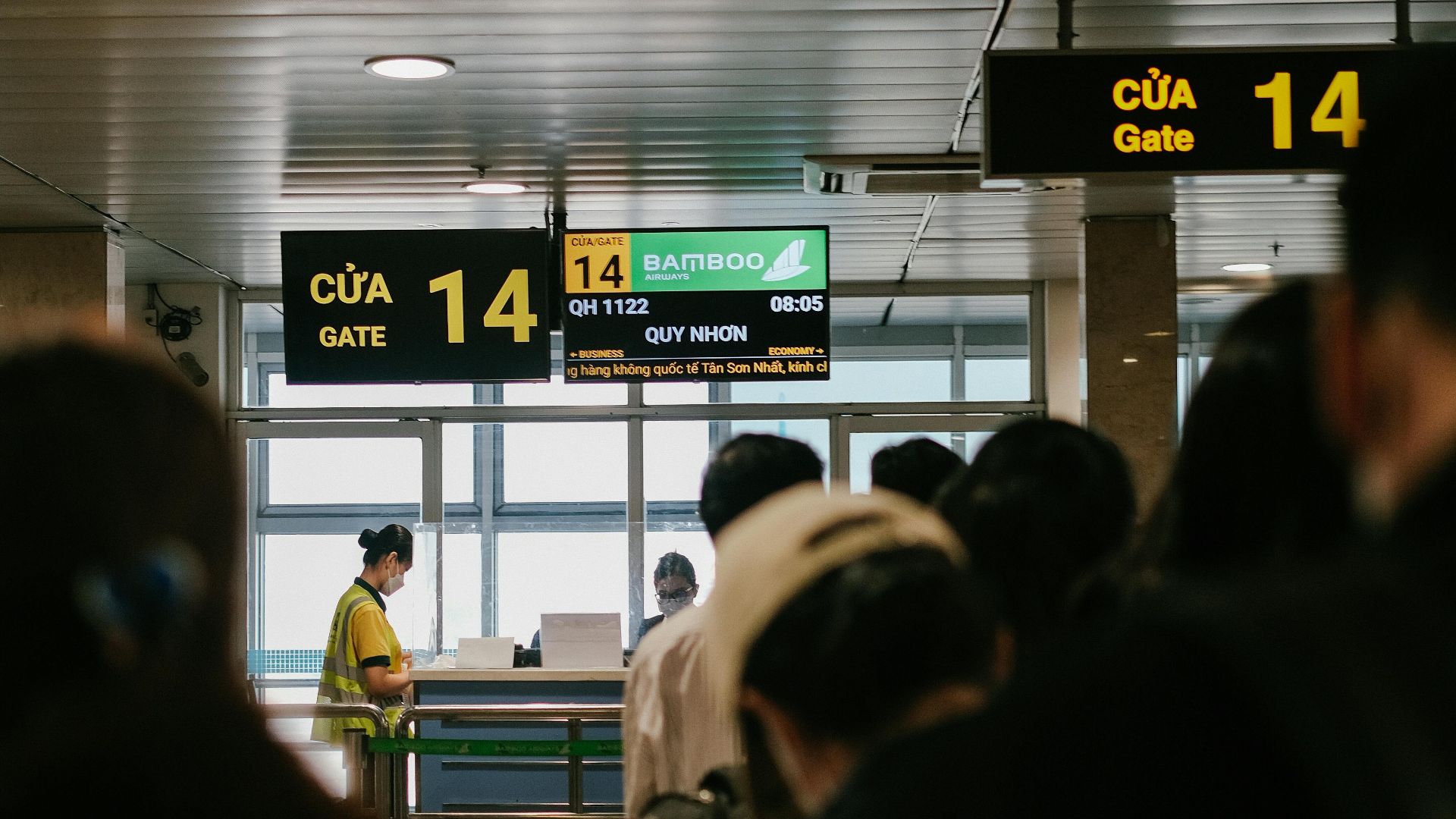 People standing in line at an airport gate, waiting to board a flight.