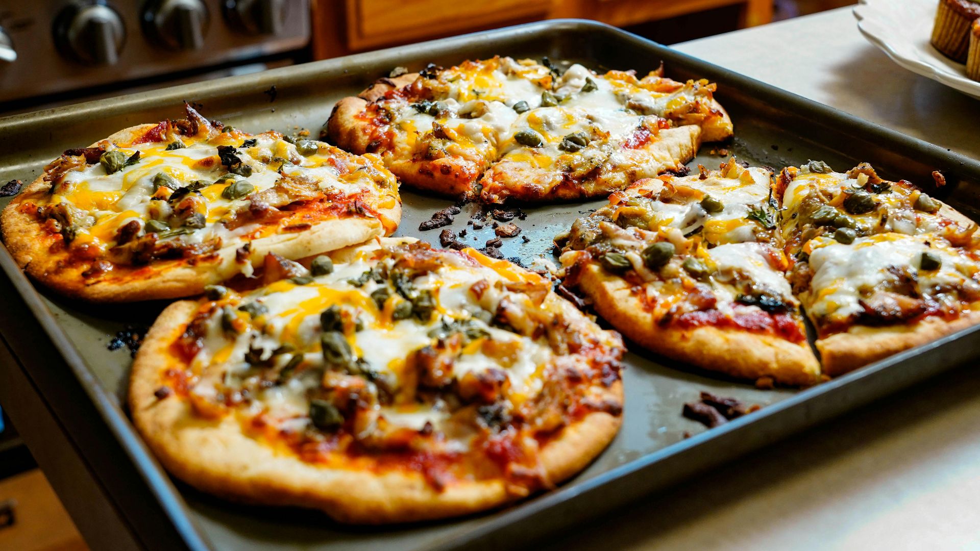 Freshly baked pizzas with melted cheese on a kitchen counter, ideal for foodies.