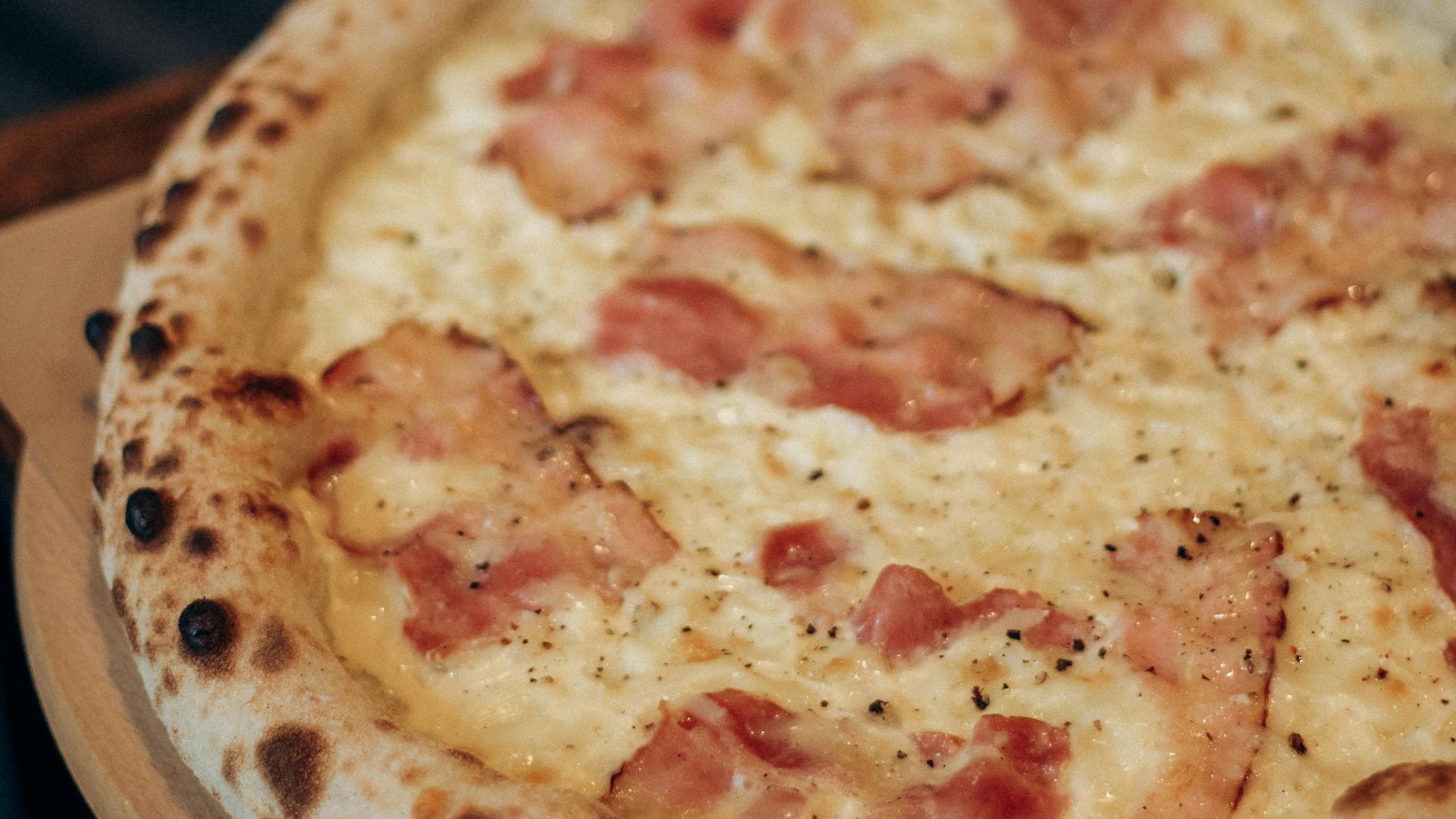 Appetizing Italian pizza topped with mozzarella cheese and crispy bacon, ideal for food lovers.