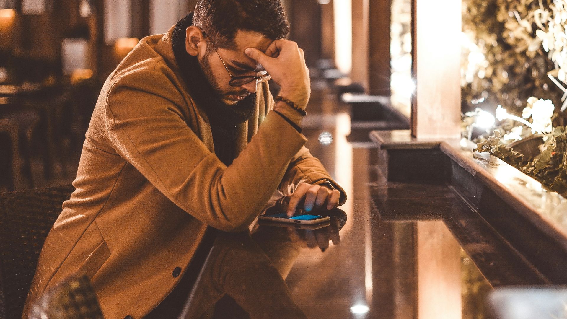 man in brown jacket sitting on brown wooden bench