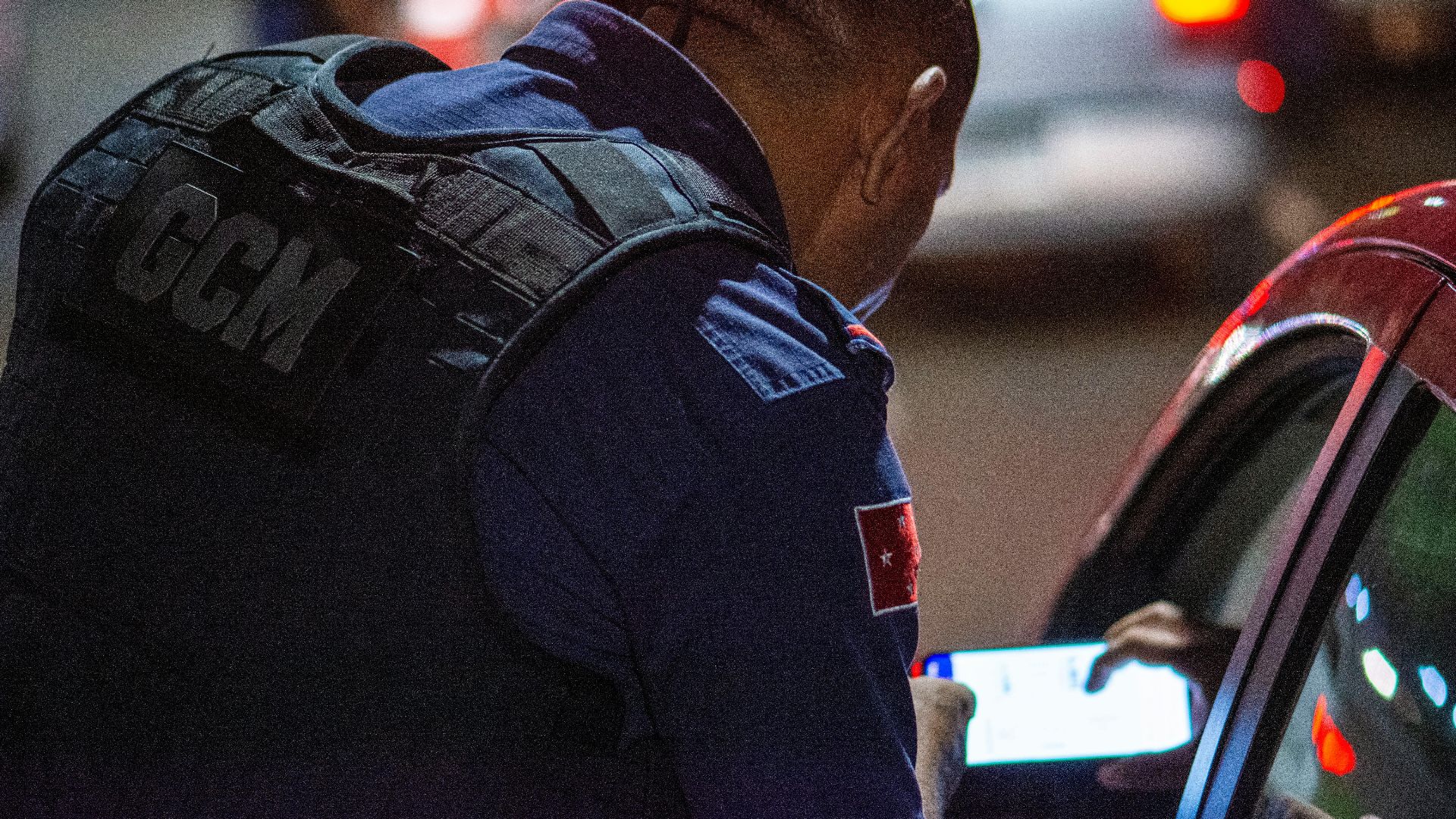 A GCM officer checks documents during night traffic control in Londrina, Brazil.