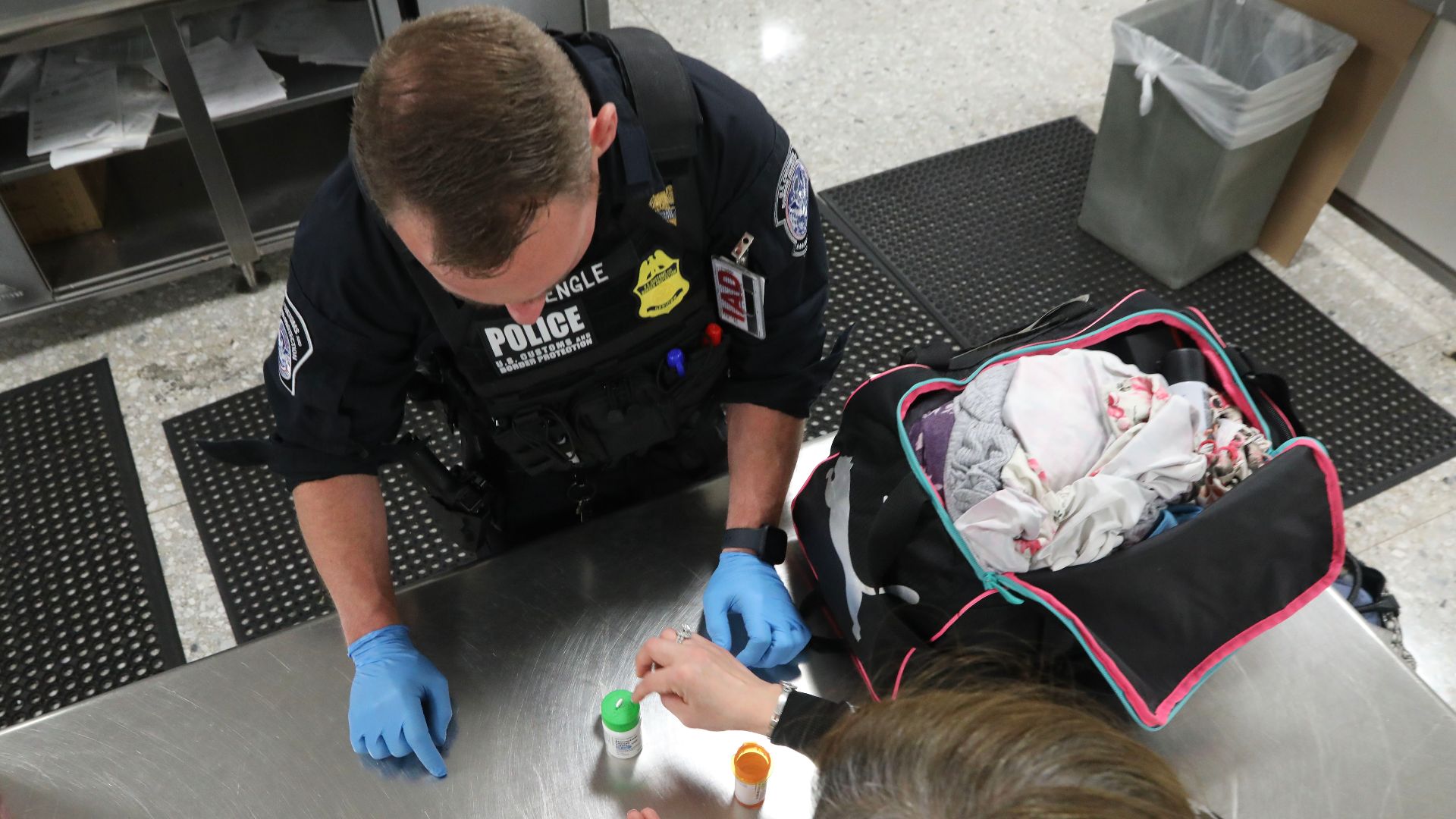 A U.S. Customs and Border Protection officer inspects medicine found in a passenger’s bag who had been referred for secondary examination, April 29, 2024, Dulles Airport, Sterling, Va.
