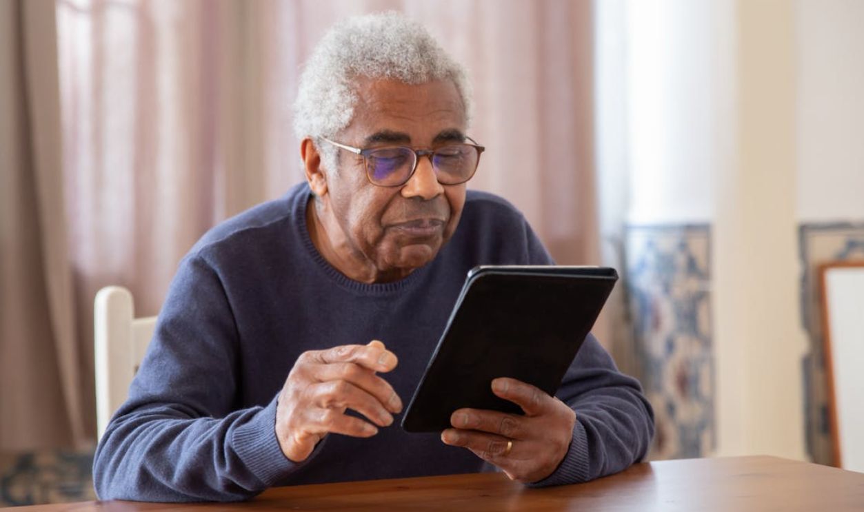 Senior man using a digital tablet indoors, focusing on modern technology and connection