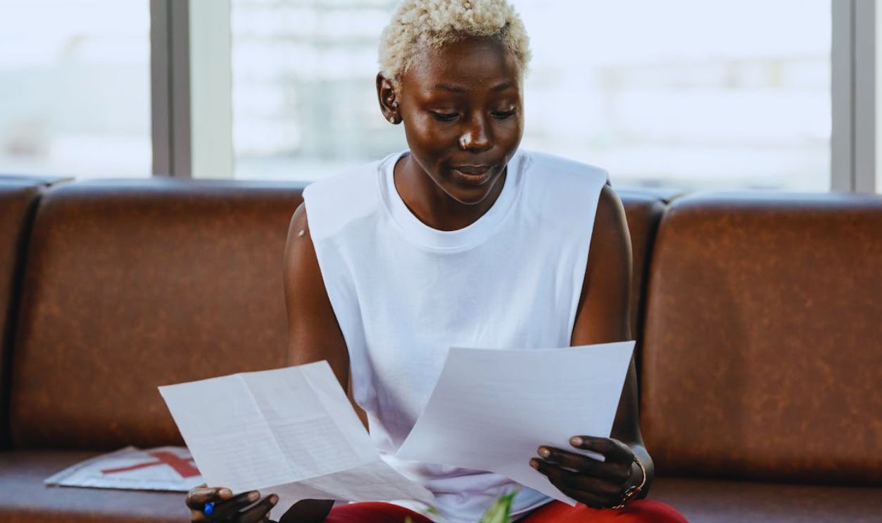 Confident young woman reviewing important documents on a sofa in a business setting
