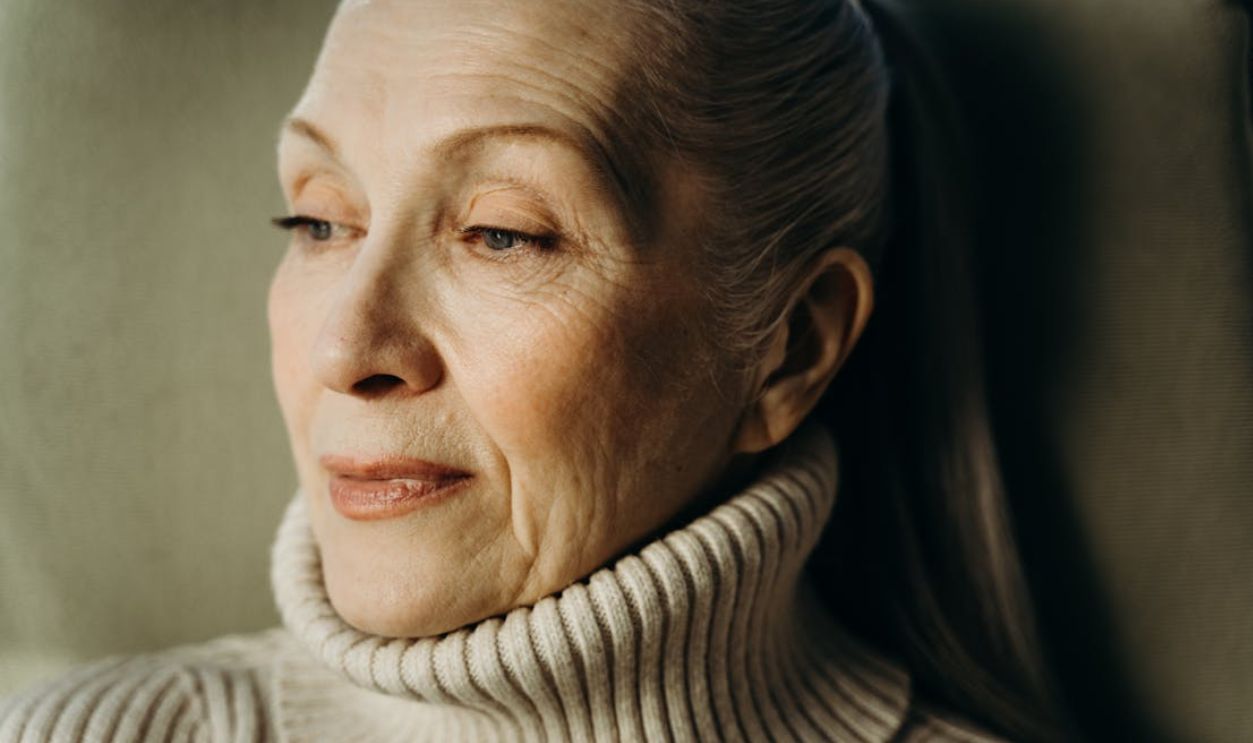 Close-up of a thoughtful senior woman wearing a cozy turtleneck sweater