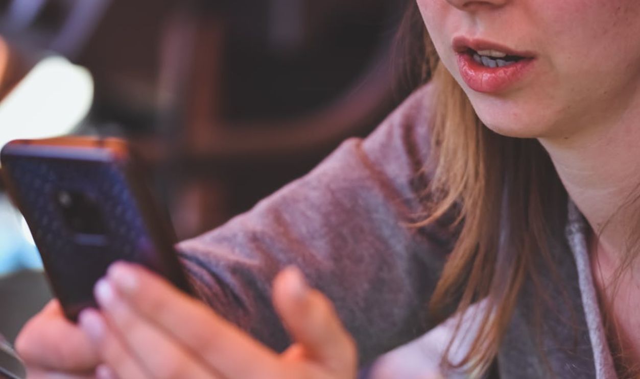 Close-up of woman using smartphone inside, demonstrating focus on mobile technology and communication